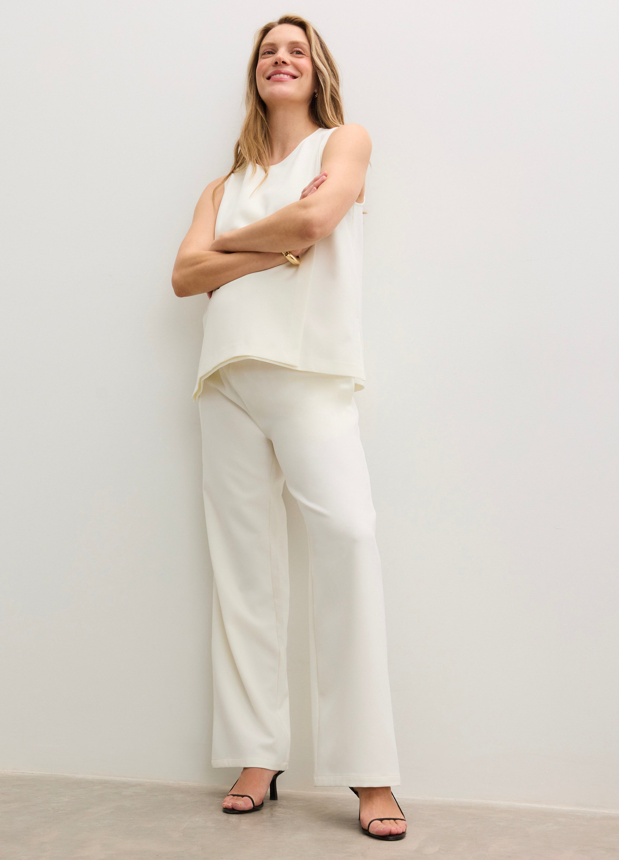 Cream wide-leg maternity pants with a smooth, stretchy fabric and high waistband designed for pregnancy comfort.