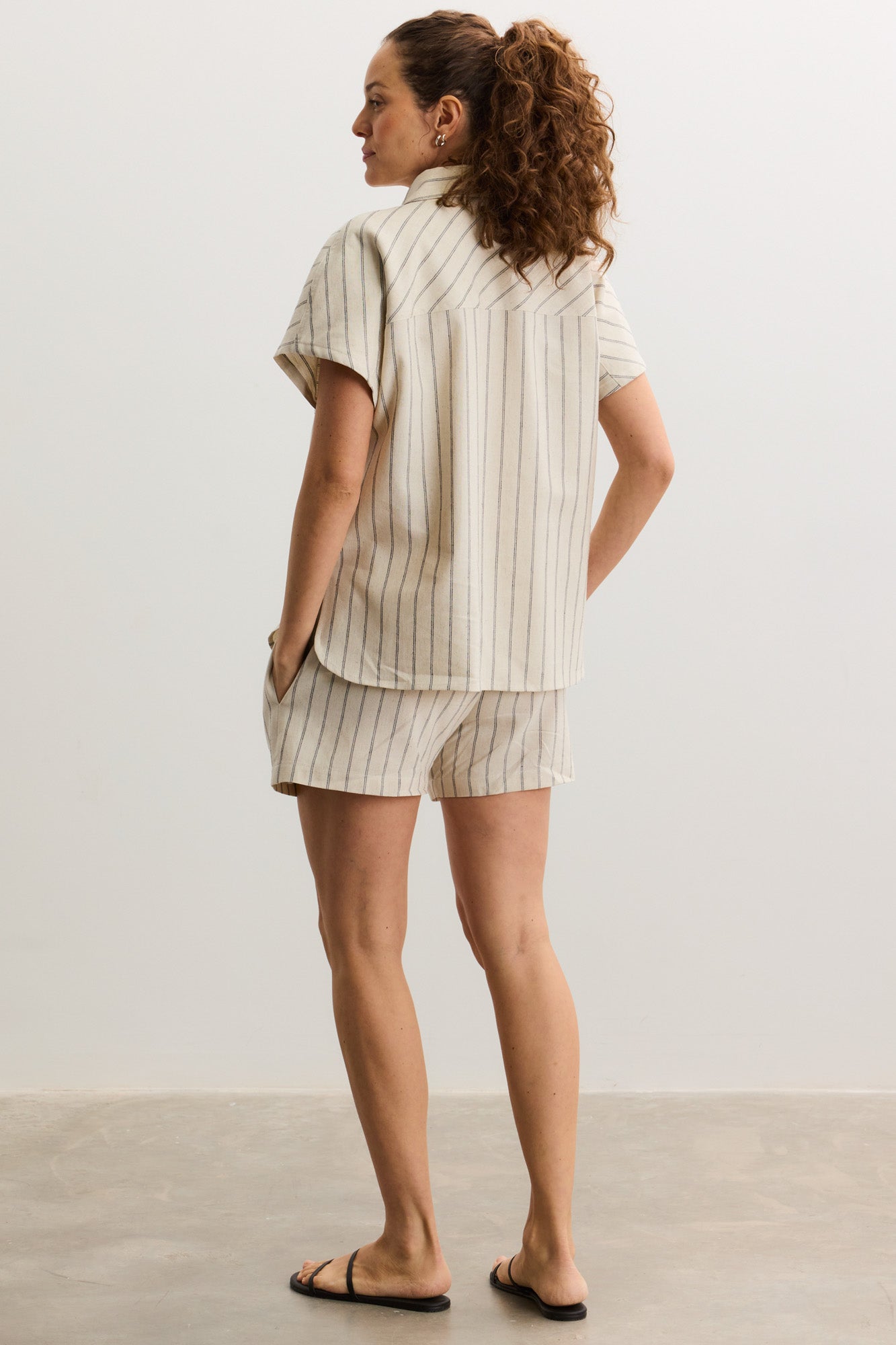 Cream and beige striped short-sleeve maternity shirt with relaxed fit and button-up back.