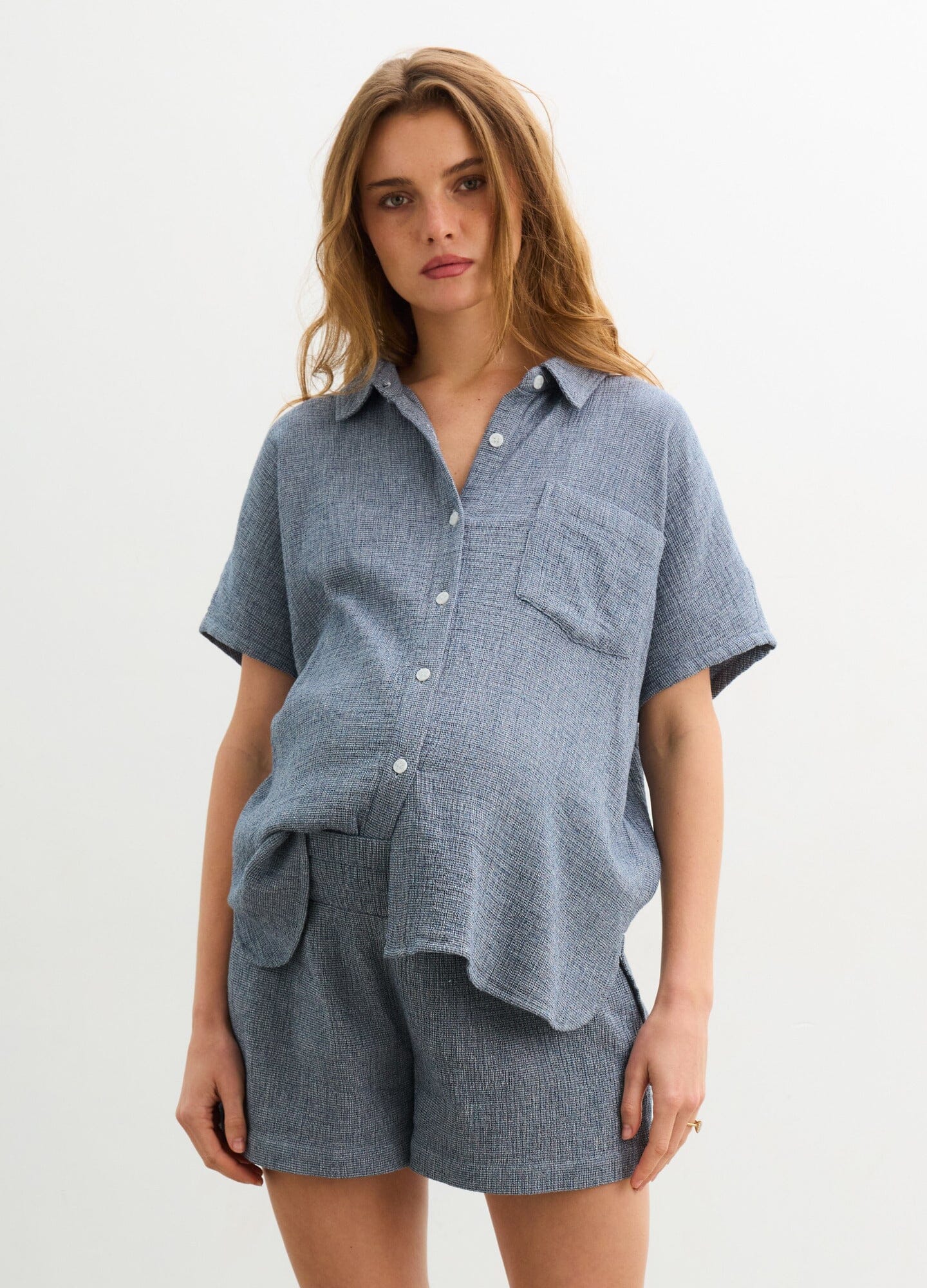 The Aubrey Shirt - Navy short-sleeve maternity shirt with front buttons and chest pocket, designed for nursing and postpartum comfort.