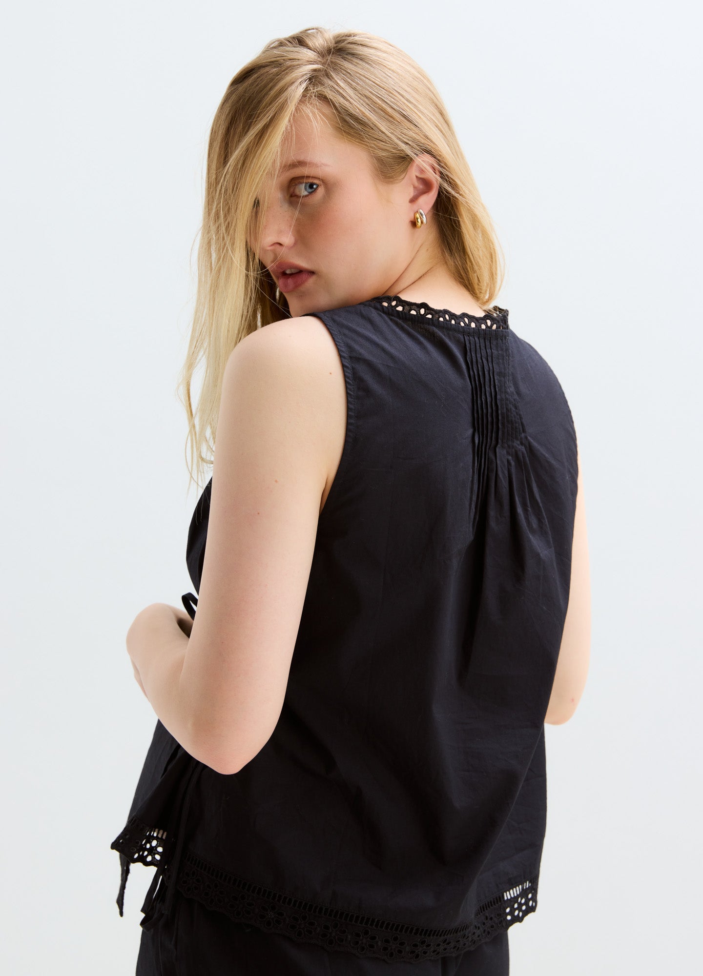 Black sleeveless maternity nursing top with lace trim and button detail at back neckline.
