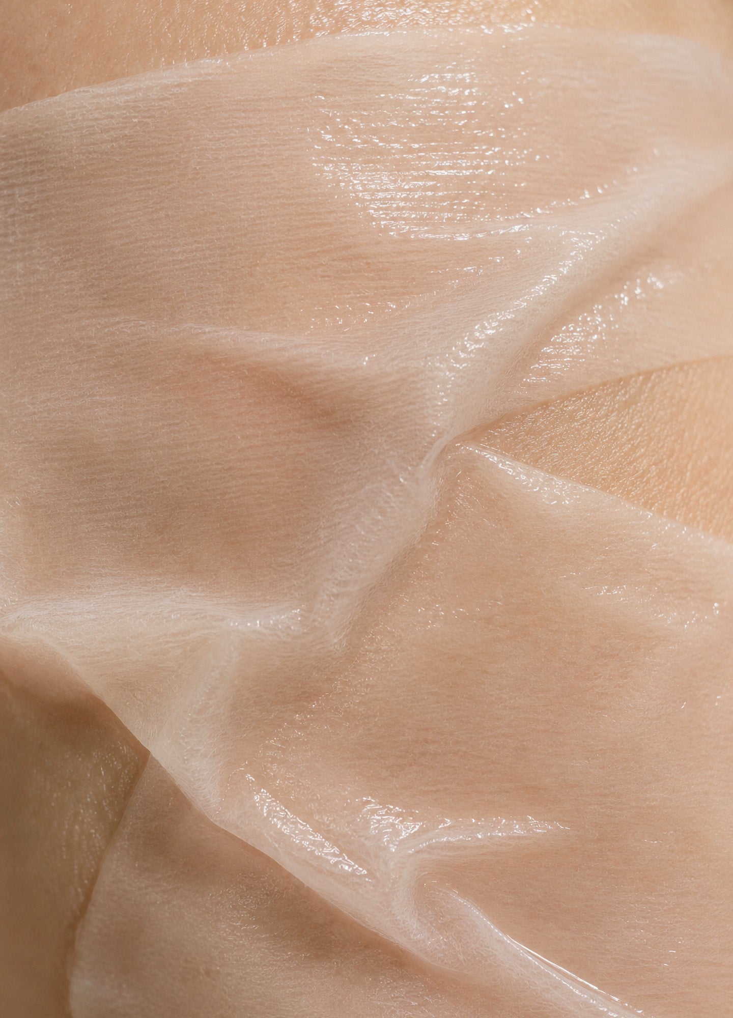 Transparent, glossy, flexible belly mask applied on skin, designed for maternity skincare.