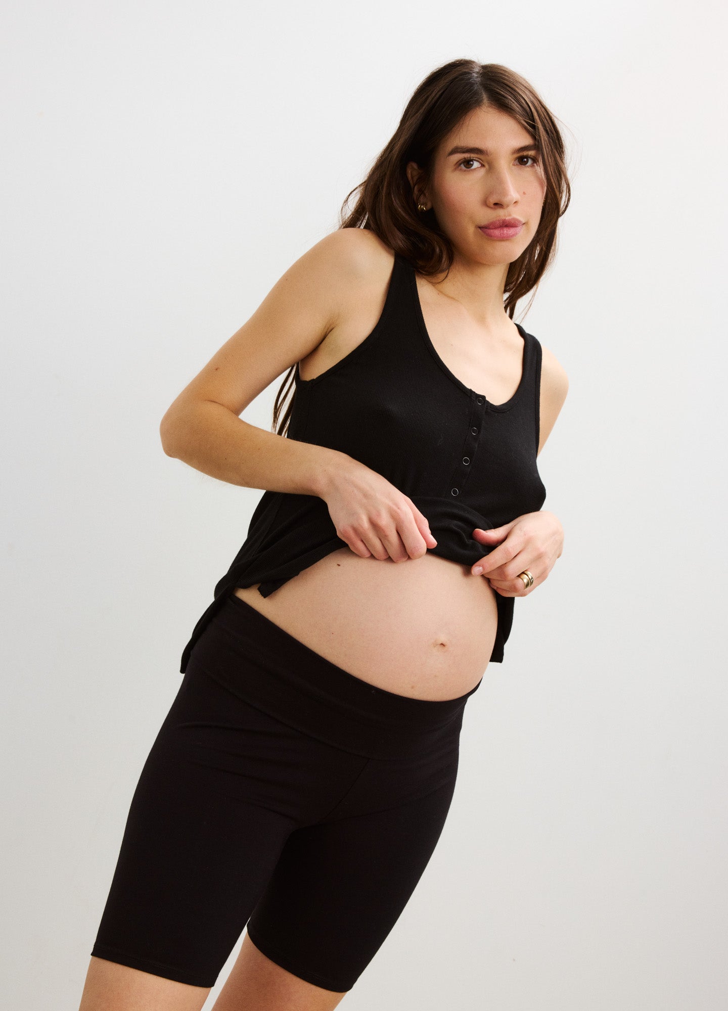 Black high-waist maternity bike shorts with smooth, stretchy fabric worn under belly.