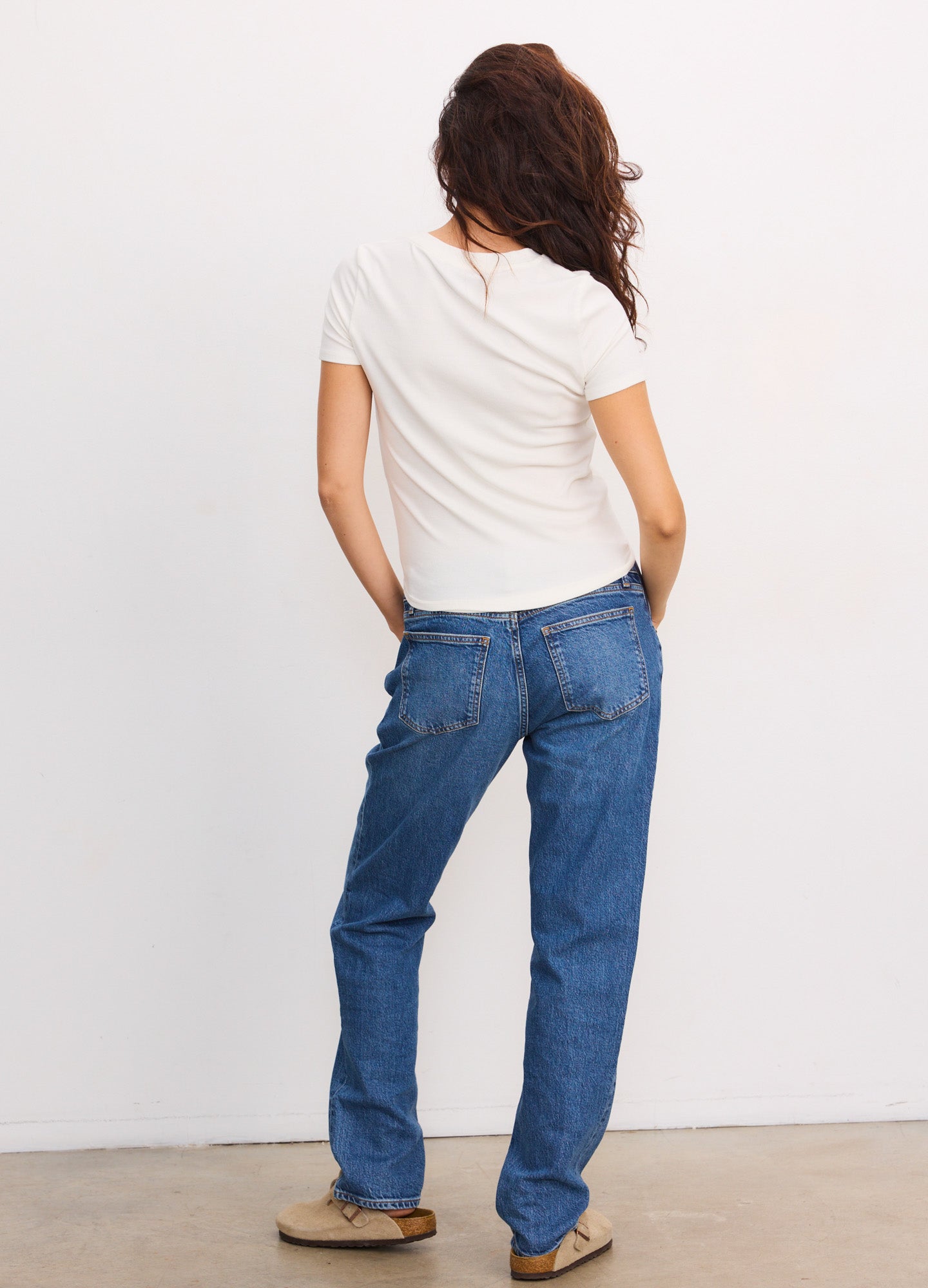 Blue denim boyfriend maternity jeans with relaxed fit and back pockets, worn by pregnant woman.