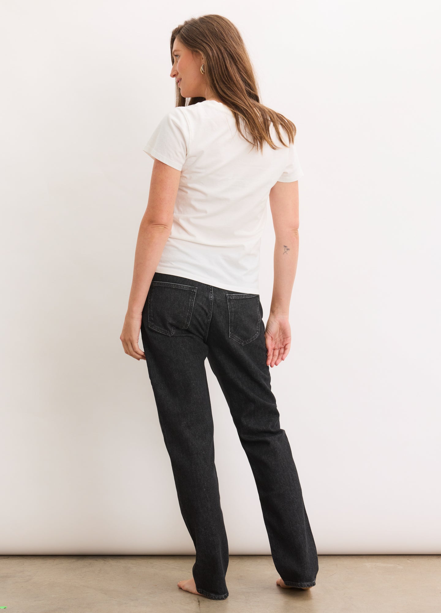 Washed black maternity boyfriend jeans on pregnant model, relaxed straight leg fit with stretchy waistband.