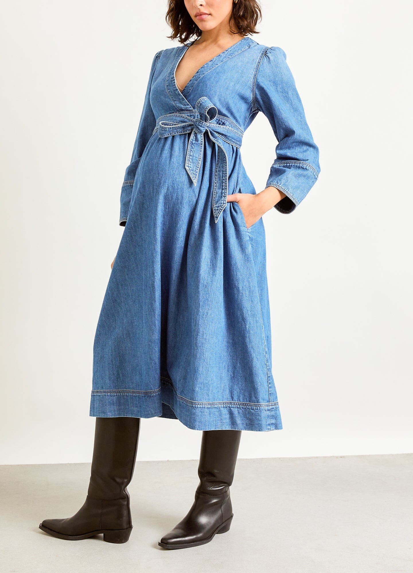 The Denim Carolina Dress - Indigo denim Carolina dress with adjustable waist tie, long sleeves, designed for maternity, nursing, and postpartum wear.