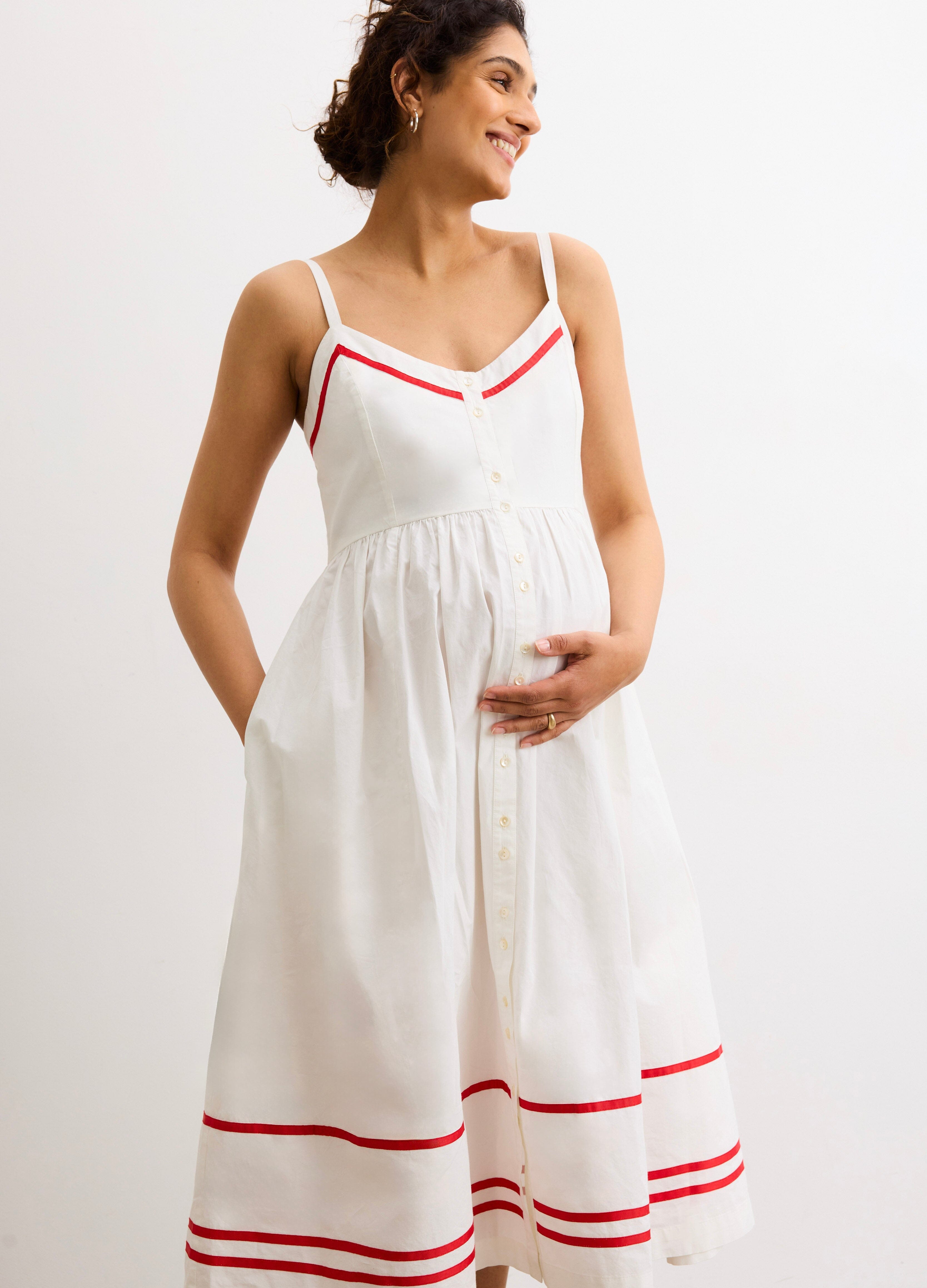 The Catalina Dress - White and red maternity dress with front buttons, adjustable straps, and a gathered waist for nursing and postpartum comfort.