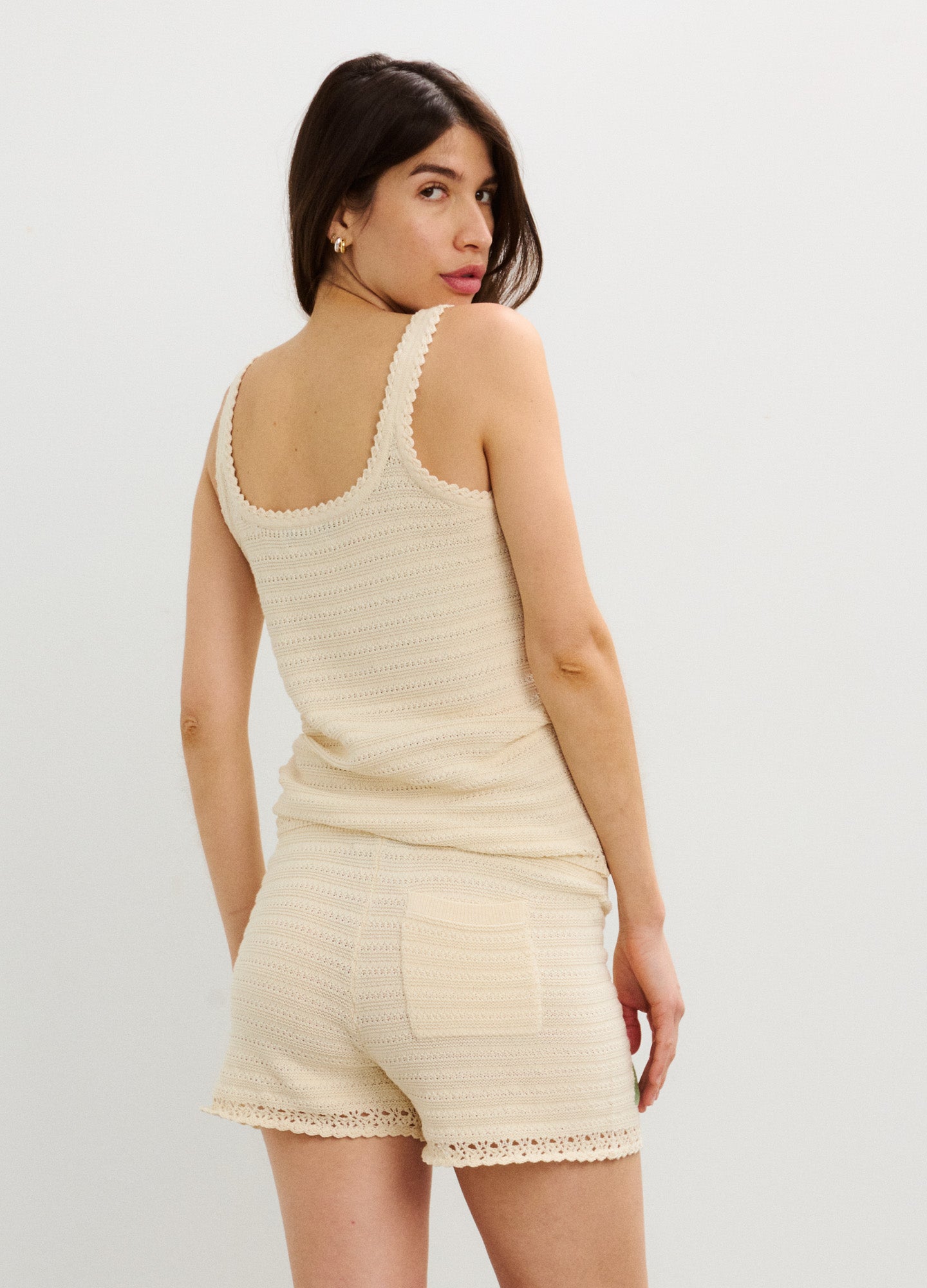 Beige ribbed maternity tank top with lace trim paired with matching ribbed shorts featuring back pockets and scalloped hems.
