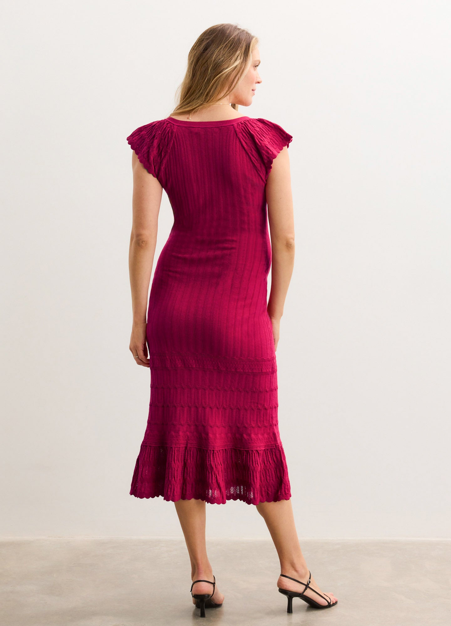 Fitted knee-length magenta maternity dress with cap sleeves and textured vertical ribbing.