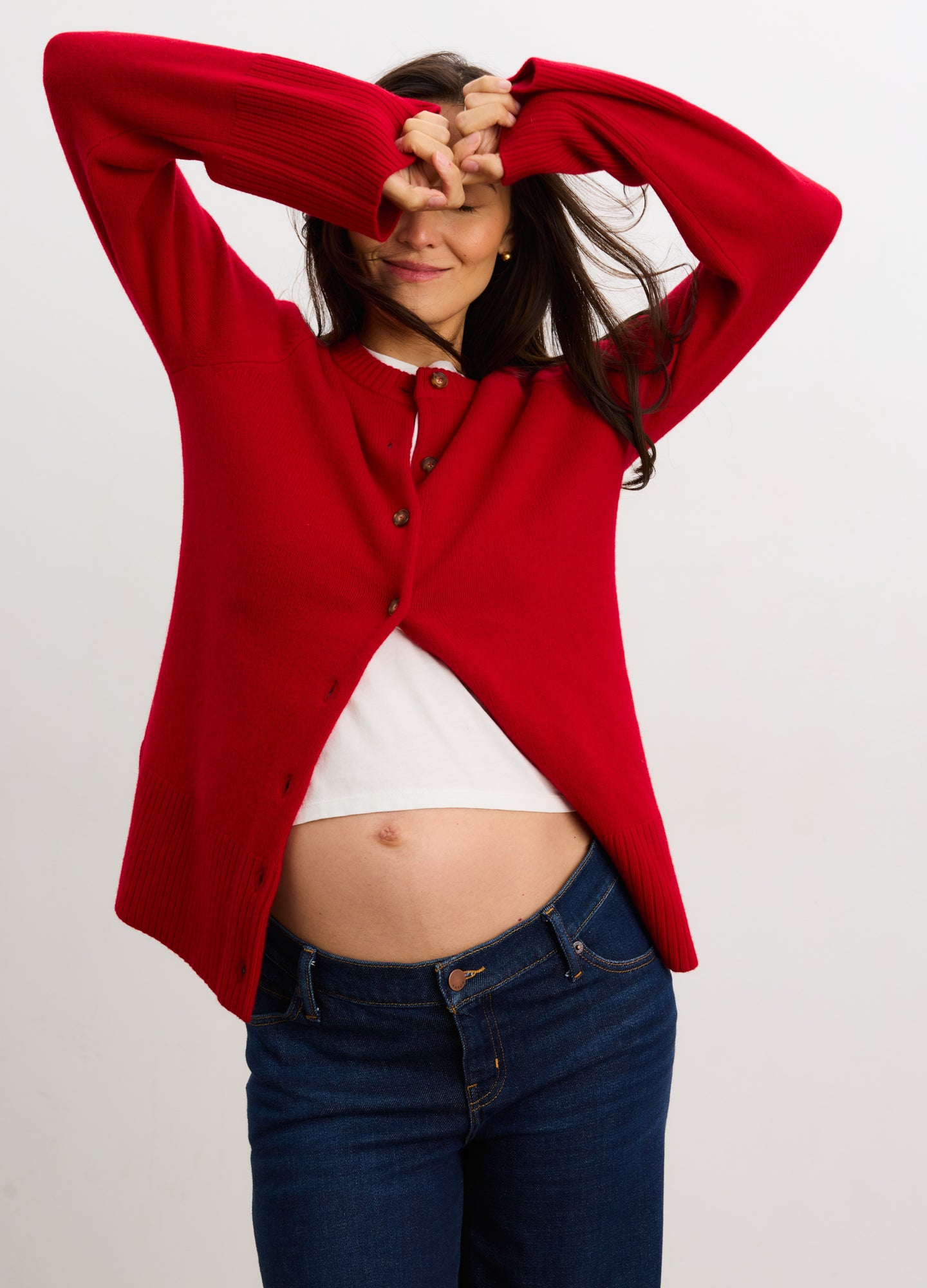 Red cashmere knit cardigan with button front, designed for maternity and nursing, worn open over white top.