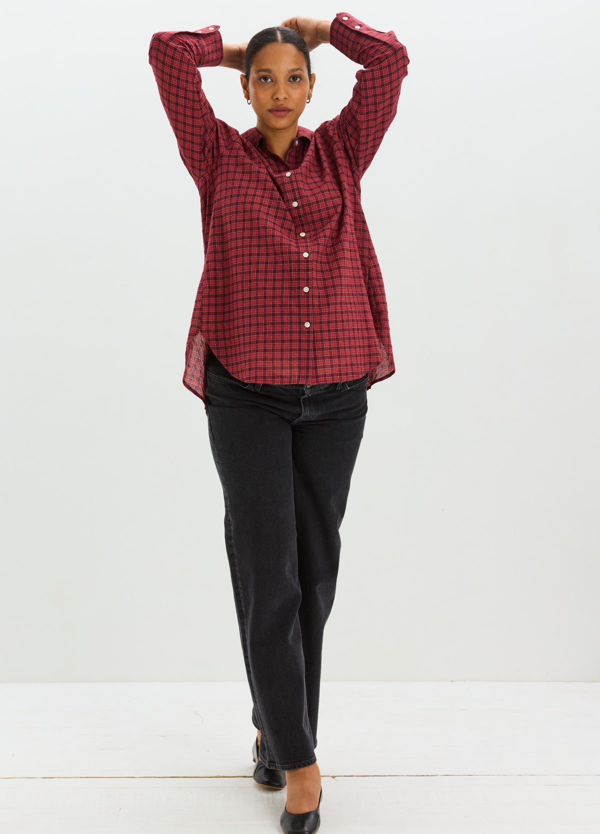 Red and black checkered maternity button-down shirt with long sleeves, paired with black pants.