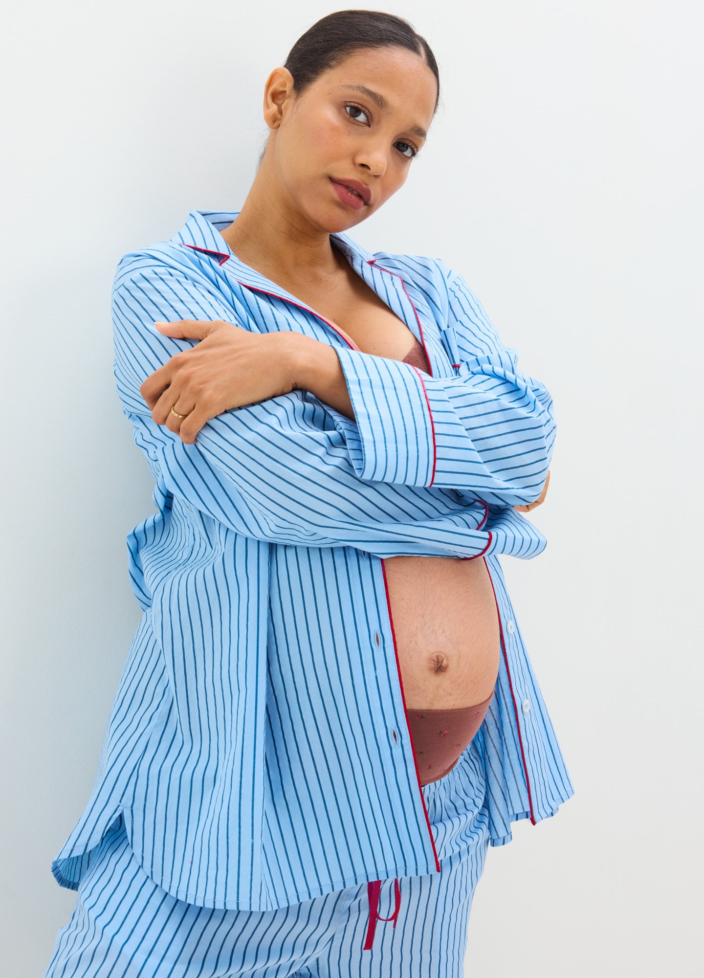 Light blue and white striped cotton maternity pajama set with long sleeves and relaxed fit, showing pregnant belly.