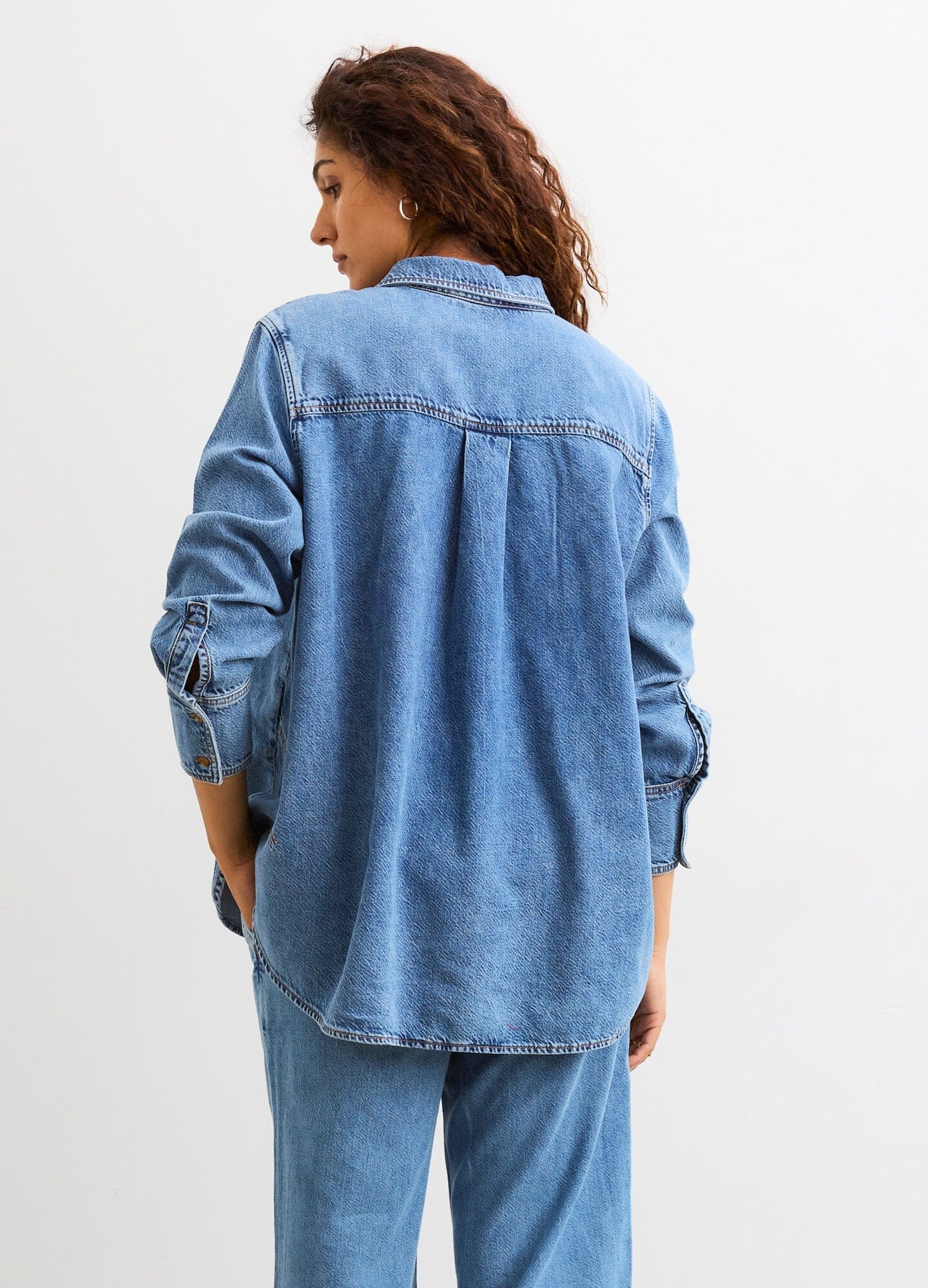 The Drapey Denim Boyfriend Shirt - Light blue soft denim maternity shirt unbuttoned to show pregnancy with long sleeves and relaxed fit for nursing and.