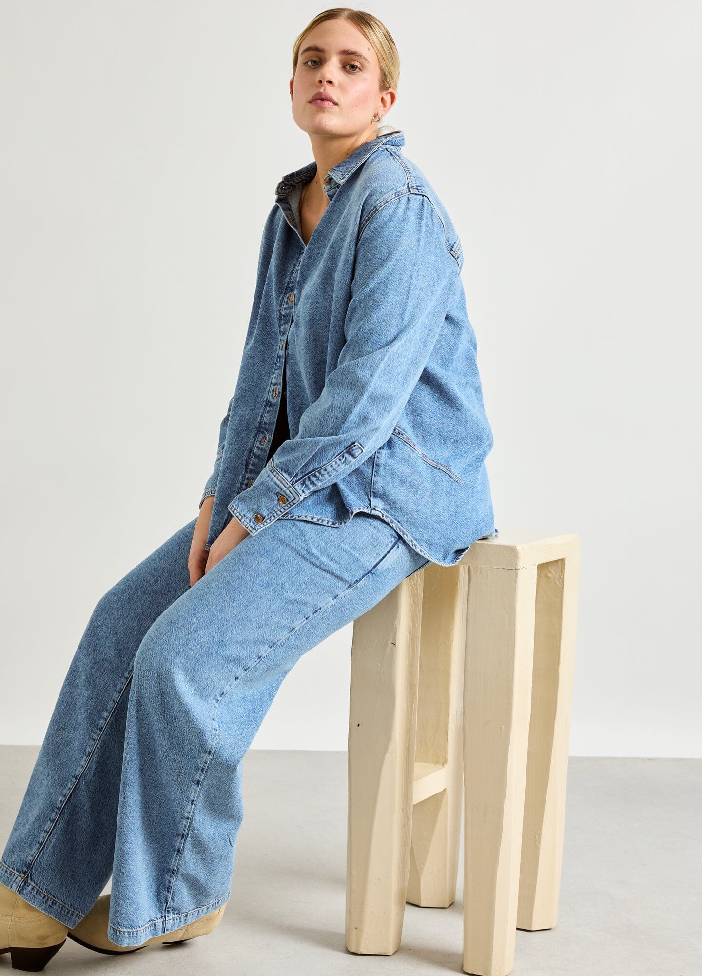 The Drapey Denim Boyfriend Shirt - Light blue soft denim maternity shirt unbuttoned to show pregnancy with long sleeves and relaxed fit for nursing and.