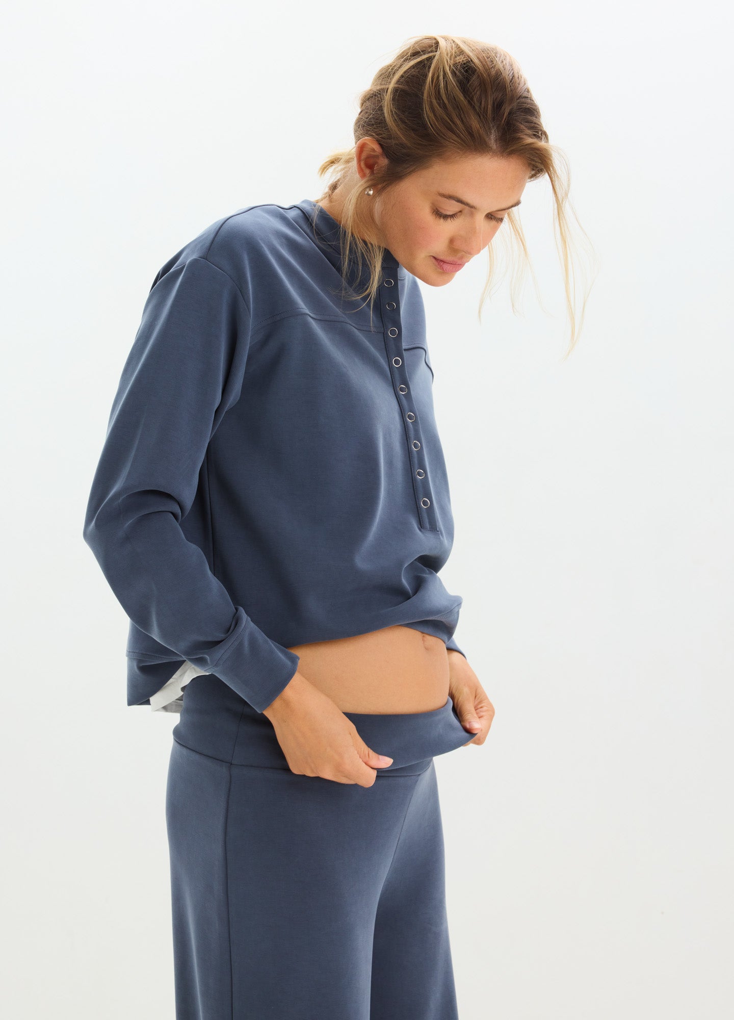 Navy blue maternity pants with soft, stretchy waistband and relaxed fit, styled with matching long-sleeve top.