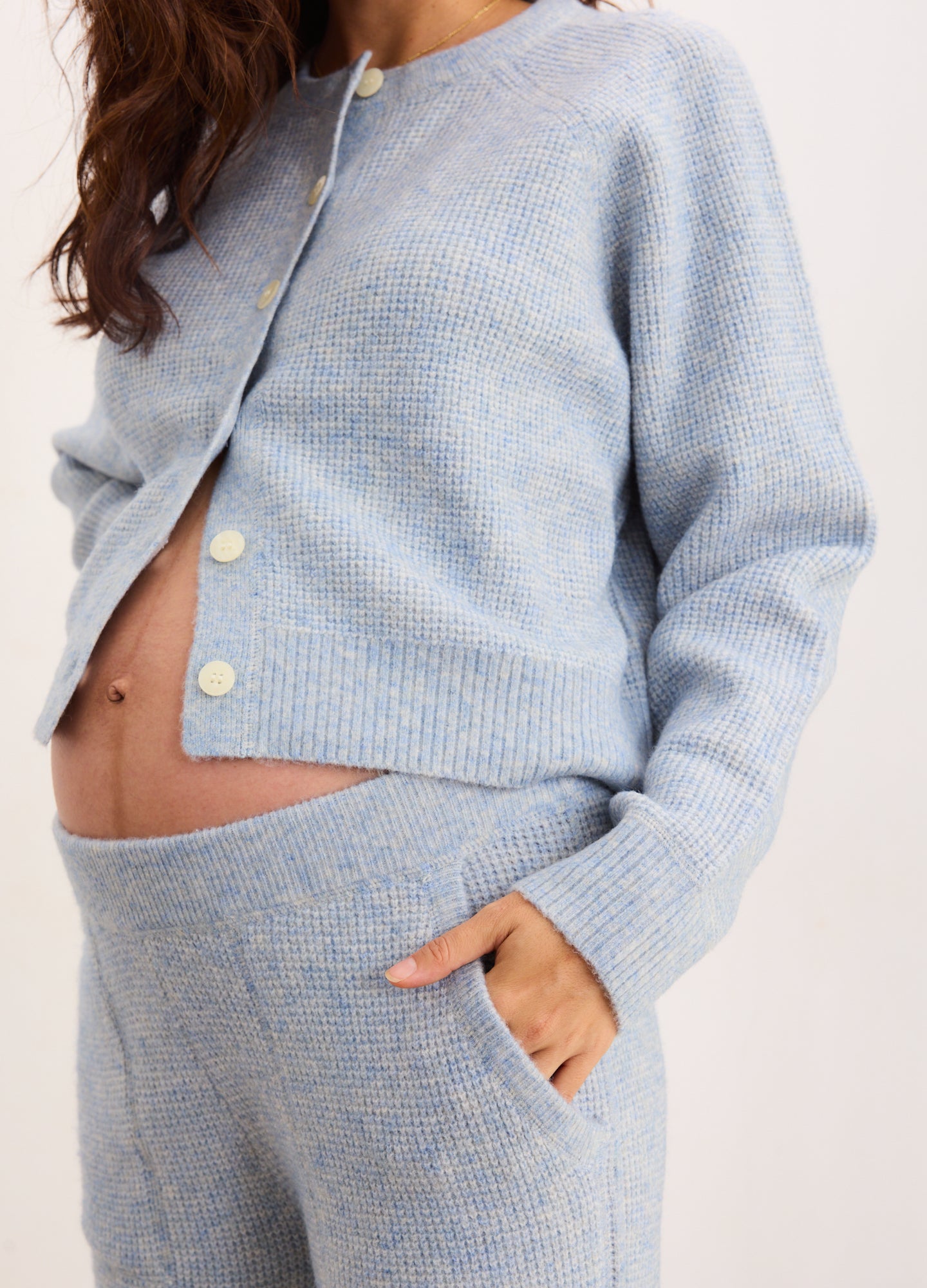 Light blue soft knit cardigan paired with matching high-waist waffle knit maternity crop pants with pockets.