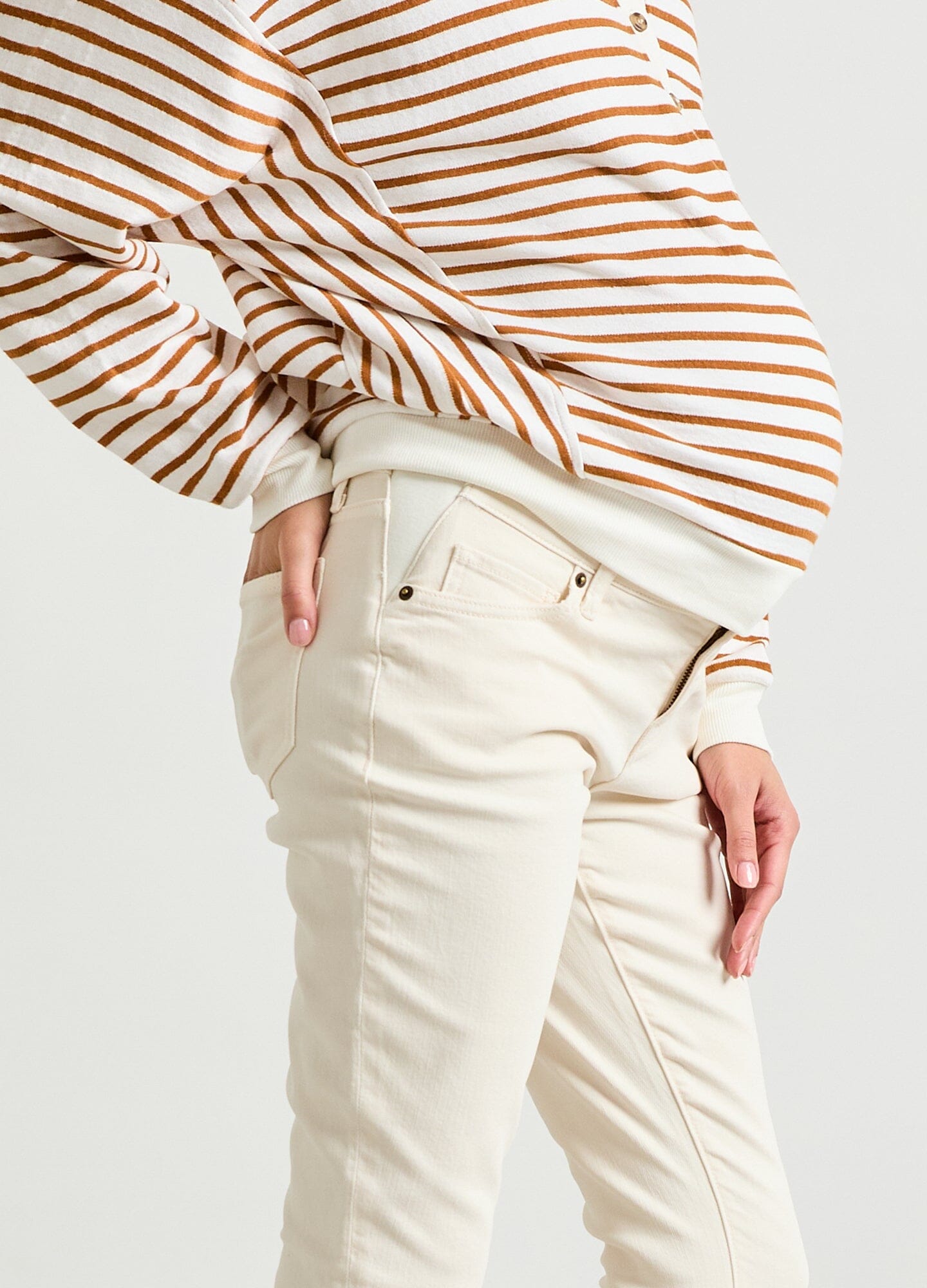 The Crop Maternity Jean - Vanilla maternity crop jeans with stretchy waistband, paired with striped long sleeve top, shown in side view.