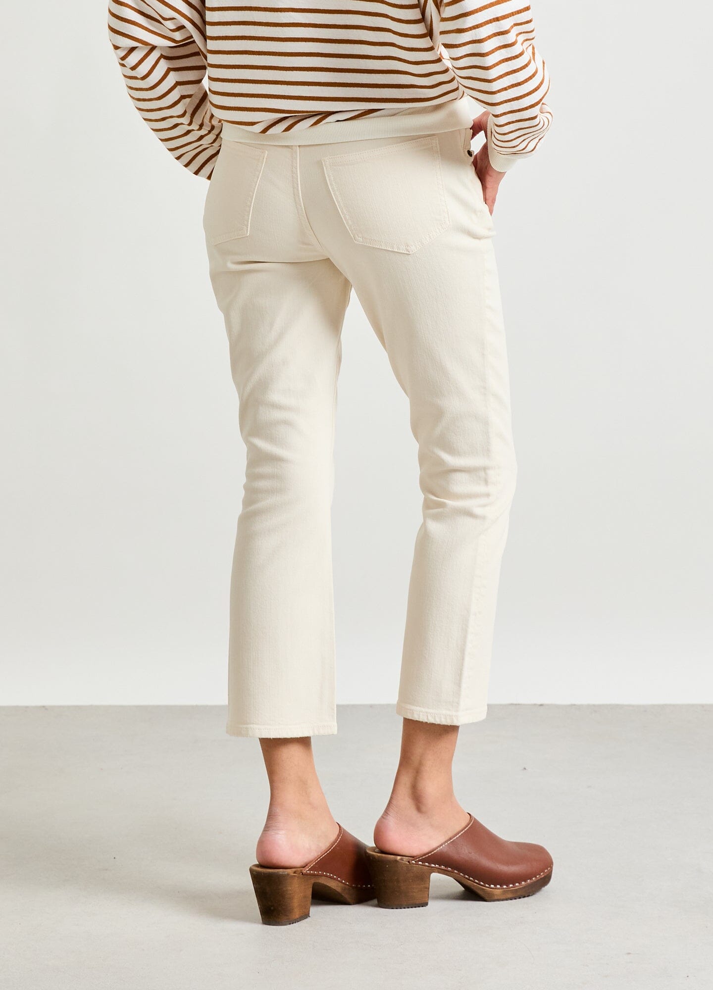 The Crop Maternity Jean - Vanilla maternity crop jeans with stretchy waistband, paired with striped long sleeve top, shown in side view.