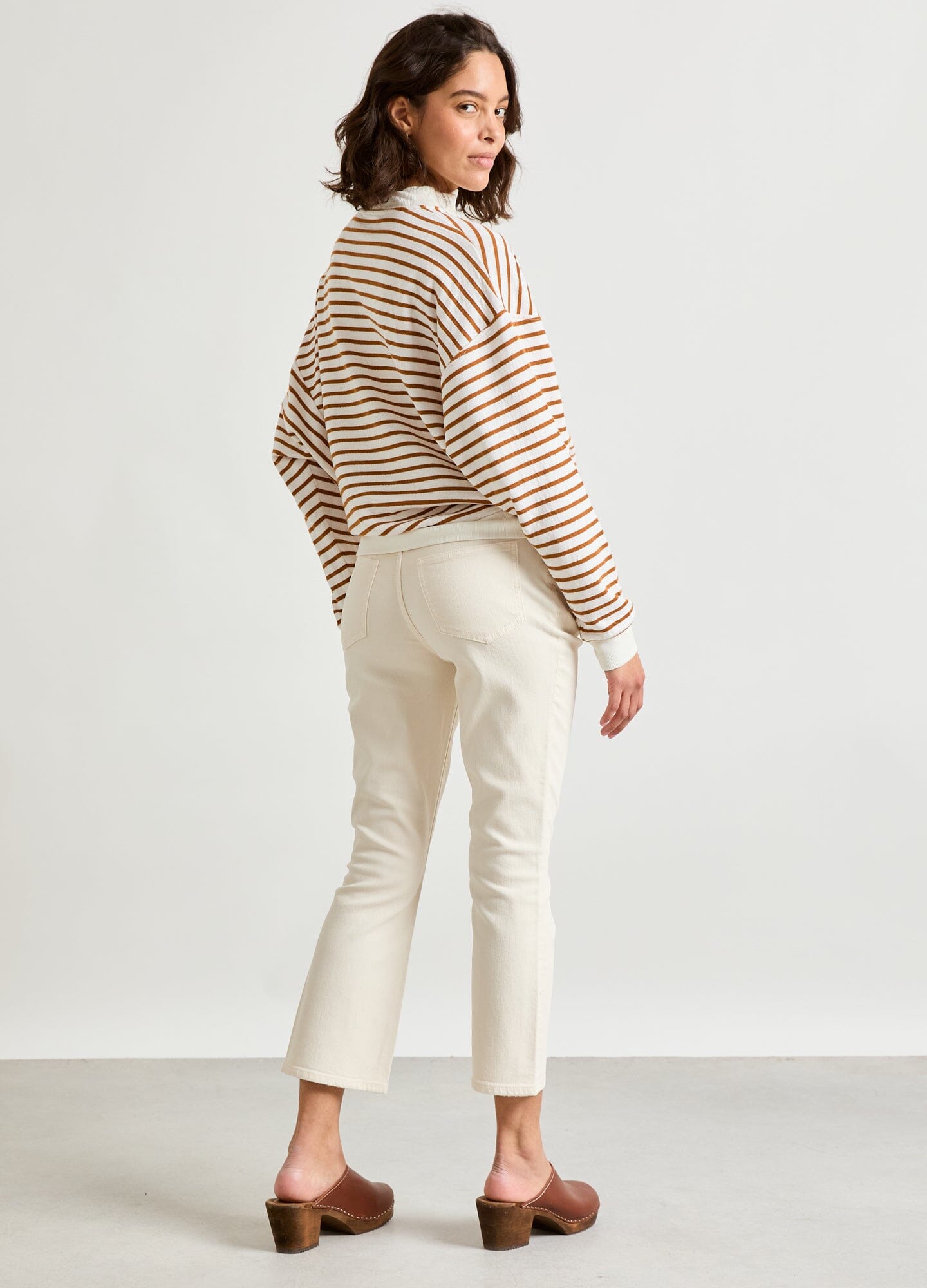 The Crop Maternity Jean - Vanilla maternity crop jeans with stretchy waistband, paired with striped long sleeve top, shown in side view.