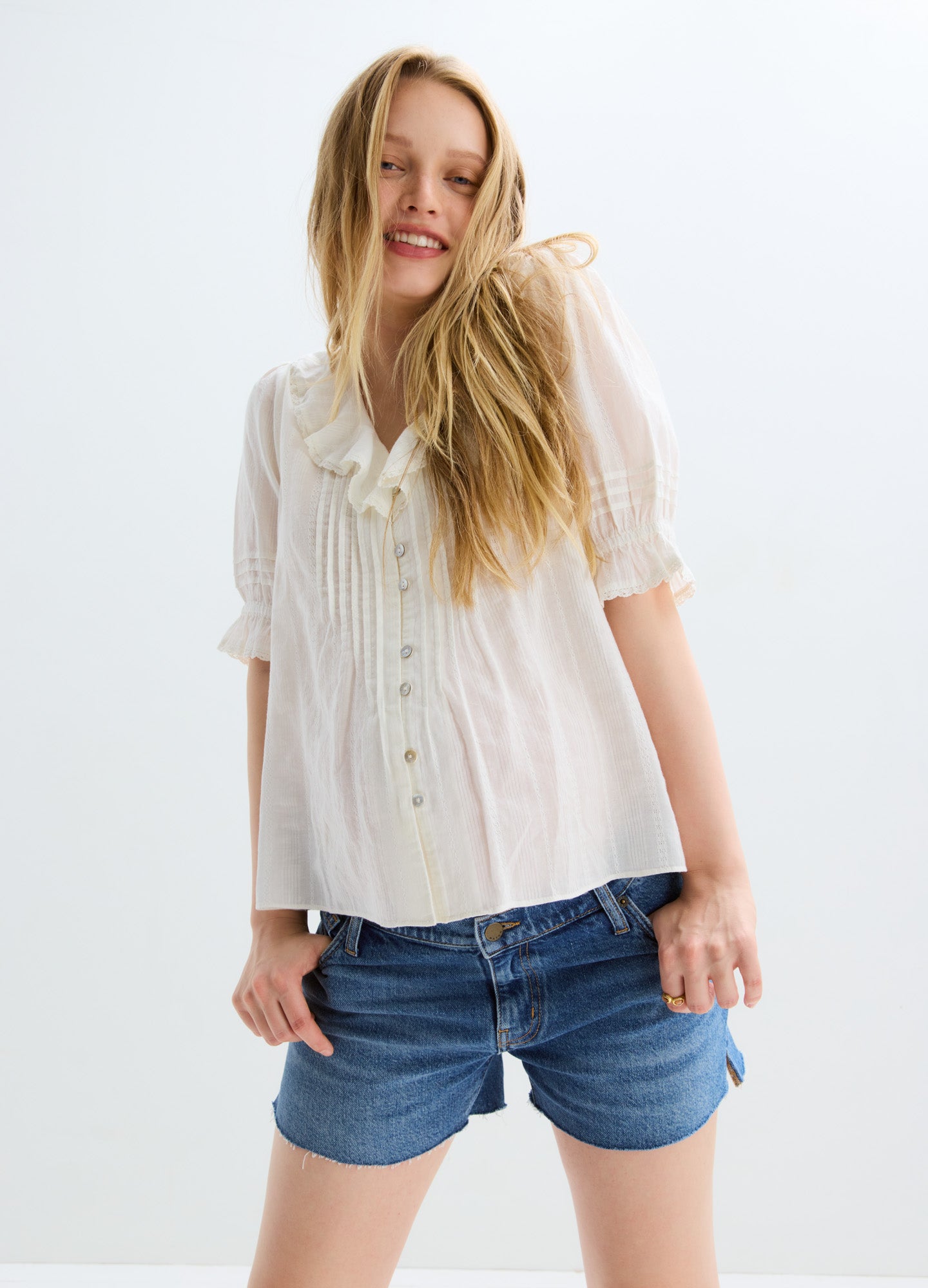 Blue denim maternity shorts with elastic waistband and rolled cuffs, worn by pregnant model.