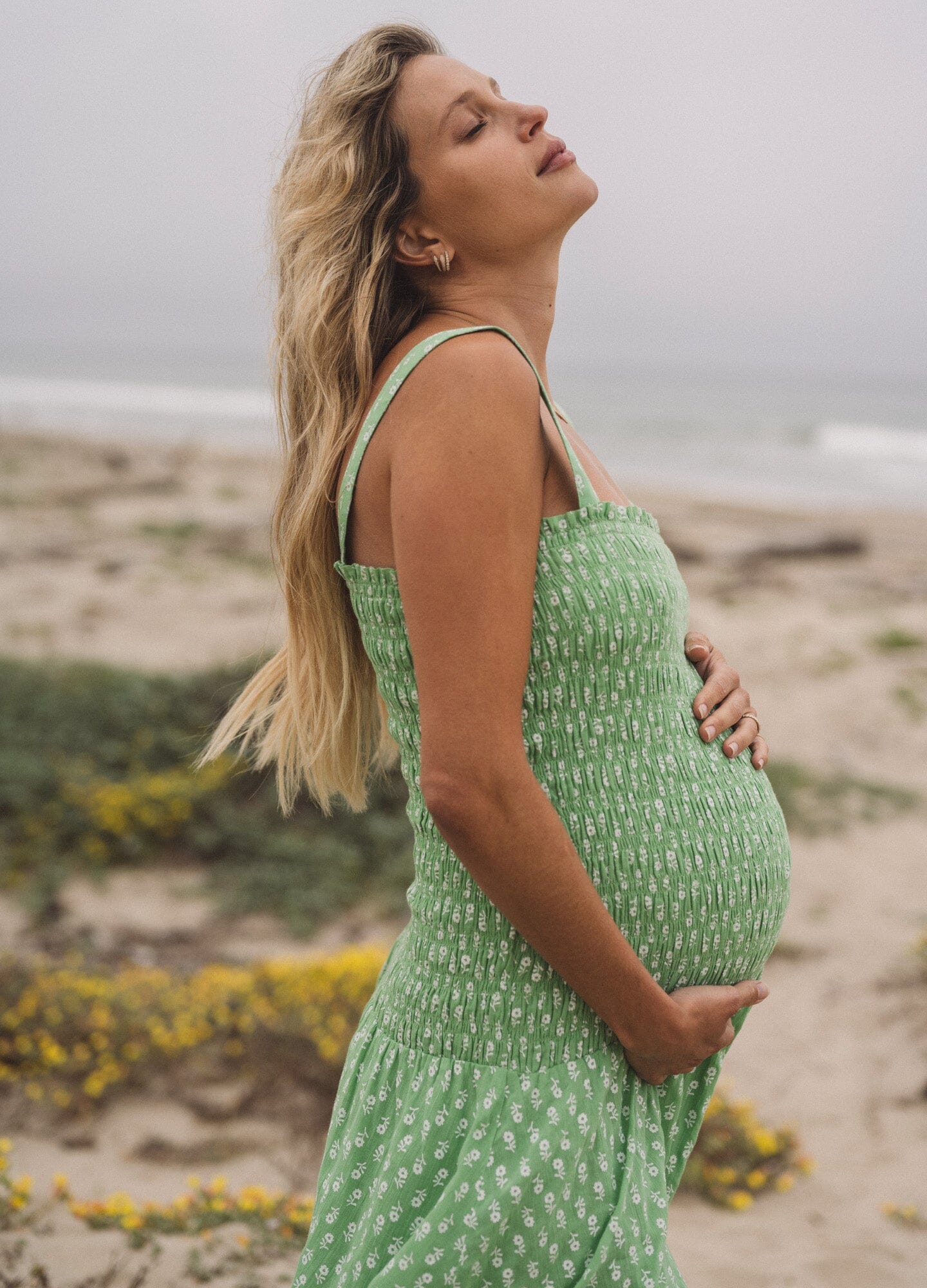 The Evie Dress - Green ditsy batik maternity dress with adjustable straps and smocked bust for pregnancy, nursing, and postpartum comfort.