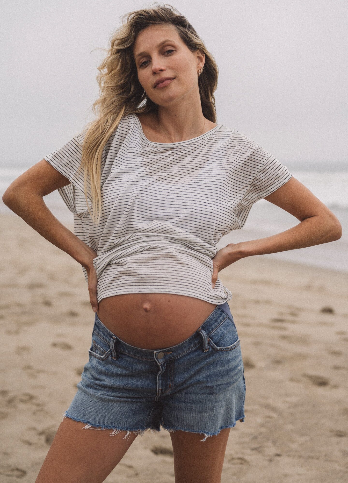 The Cut Off Maternity Short - Indigo denim maternity shorts with stretchy side panels for pregnancy, nursing, and postpartum comfort.