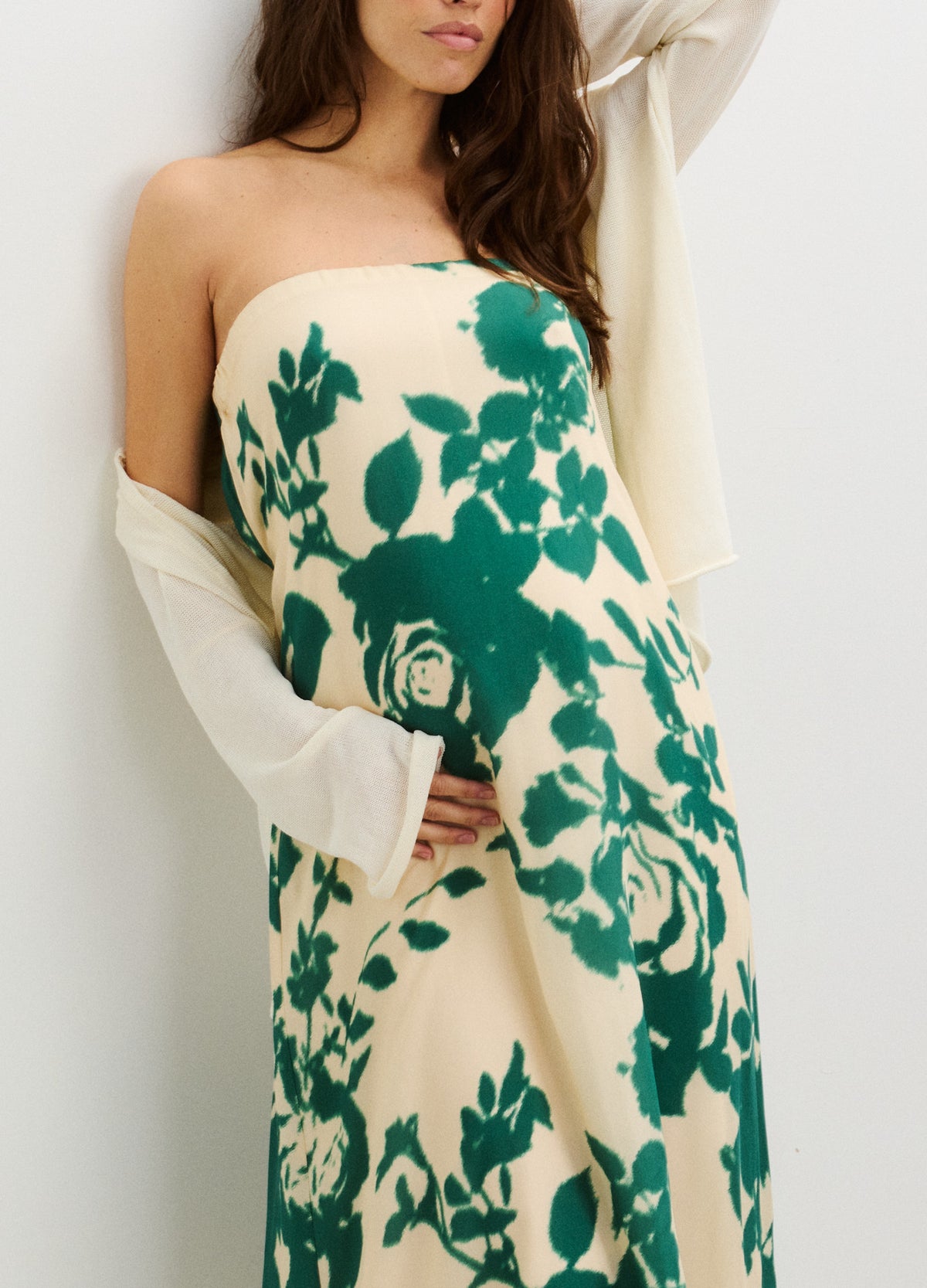 Cream strapless maternity dress with green floral print, fitted over baby bump.