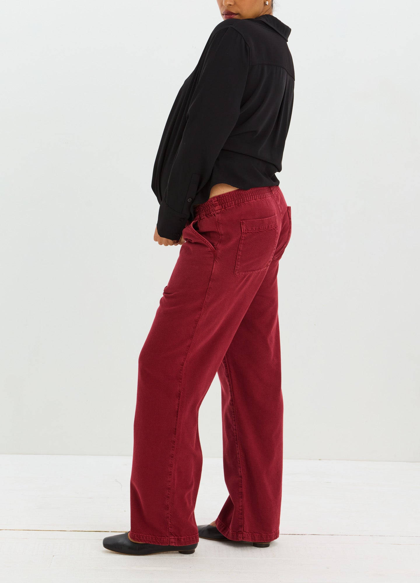 Maternity drapey denim pants in deep red with relaxed wide-leg fit and soft stretchy waistband.