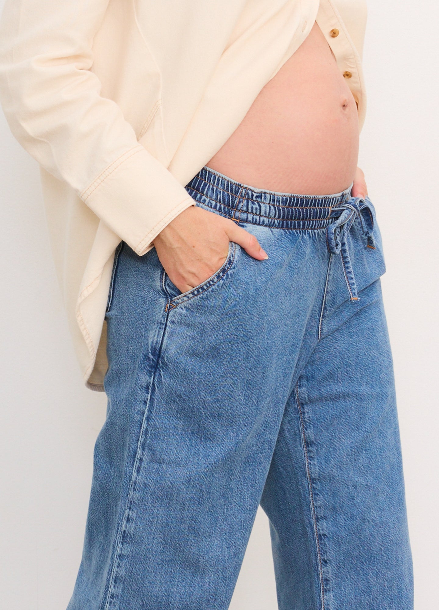 Light blue wide-leg denim maternity pants with elastic waistband and drawstring, worn by pregnant model.