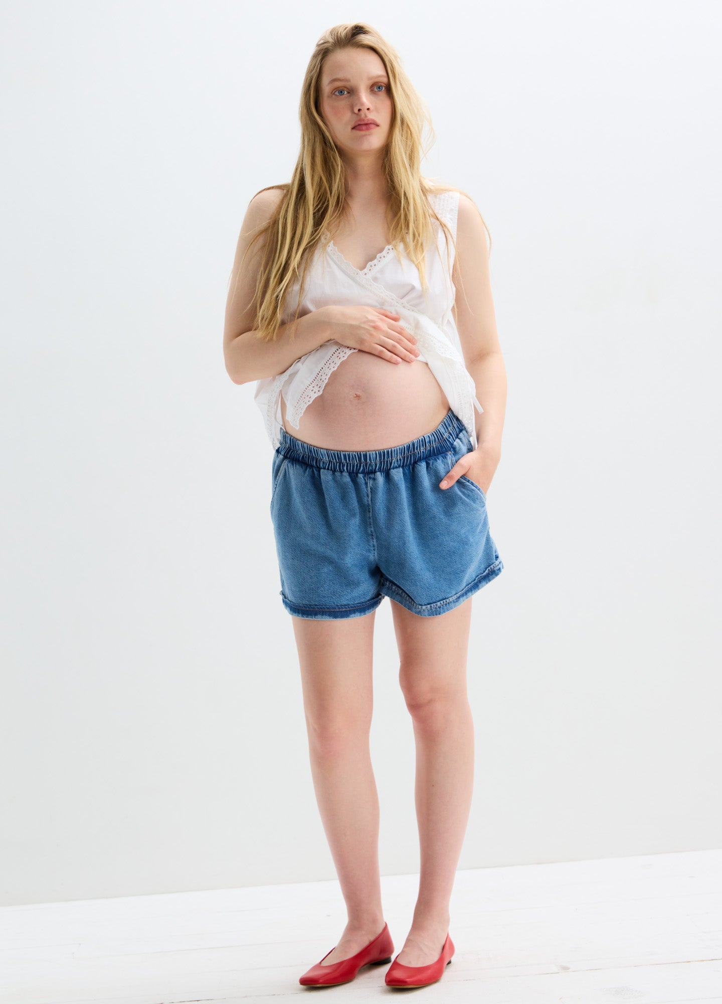 Light blue loose-fit denim maternity shorts with elastic waistband and rolled hems.