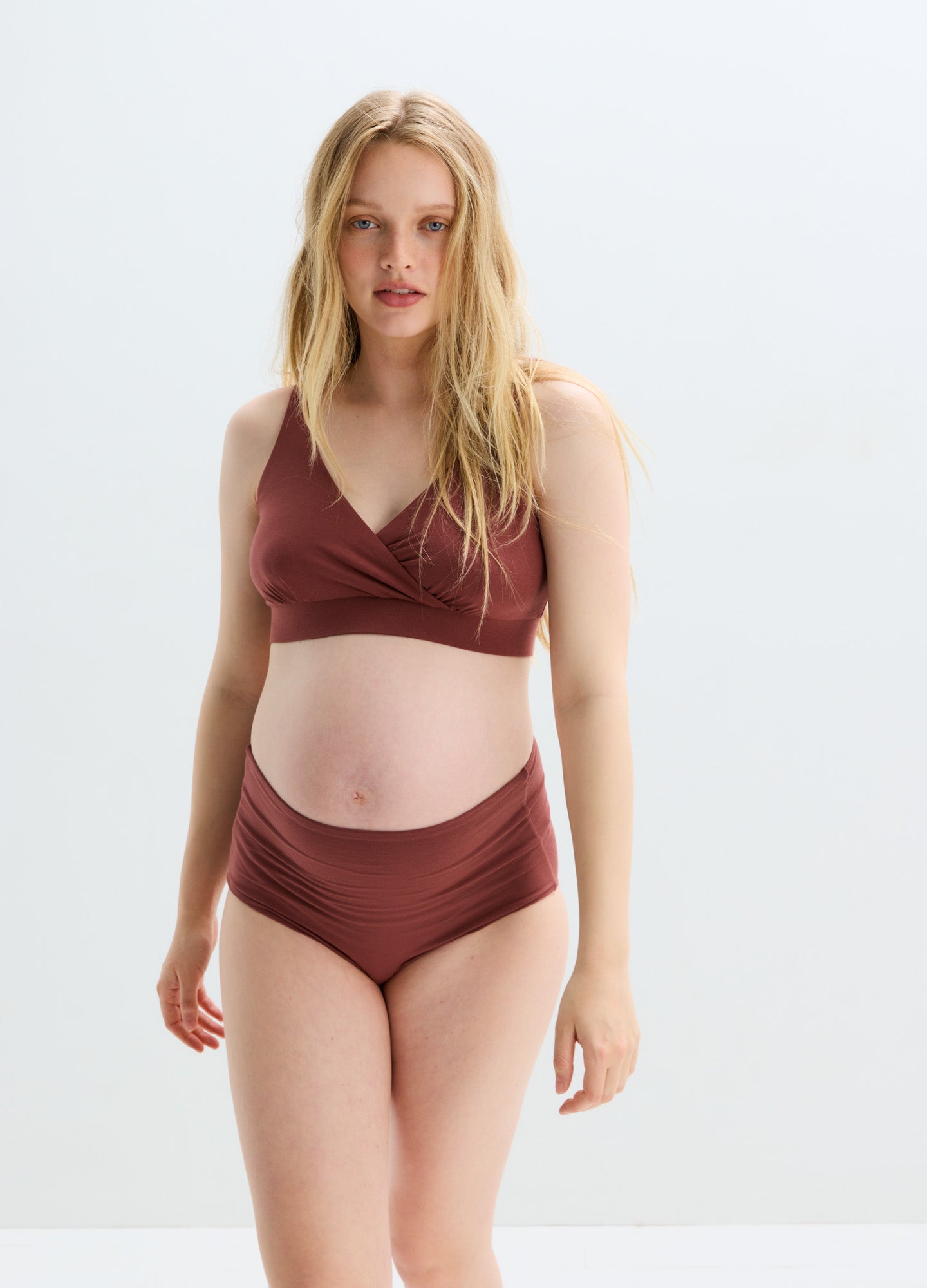 Soft brown maternity nursing bra with wide straps and seamless design on pregnant model.
