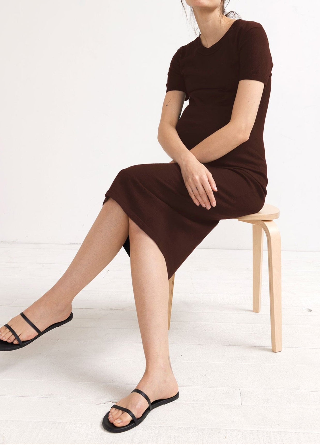 The Eliza Dress POS - Black short-sleeve maternity dress with nursing-friendly design and fitted silhouette, styled with tall black boots.