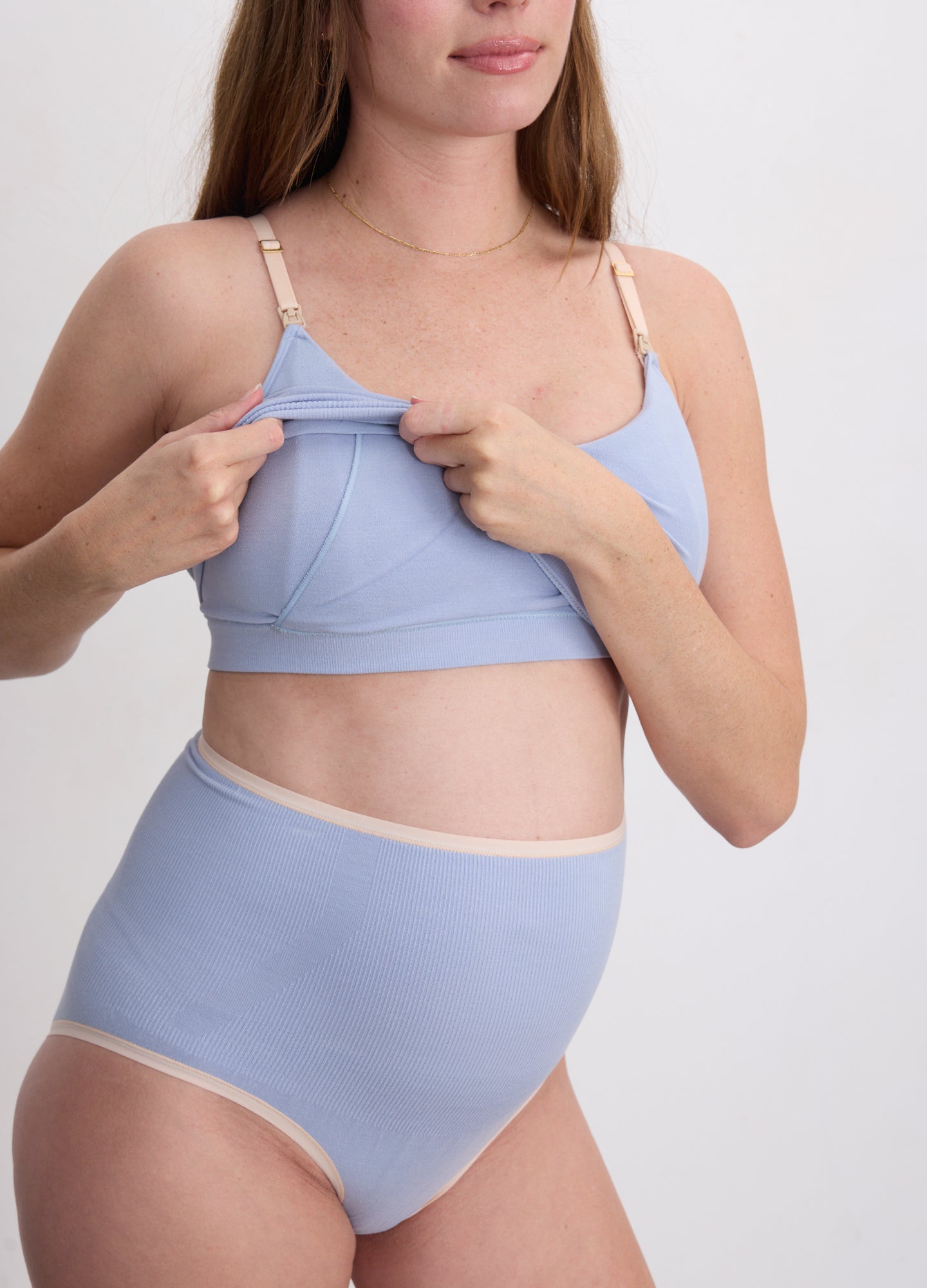 Light blue soft fabric nursing and pumping bra with adjustable straps and front flap openings.