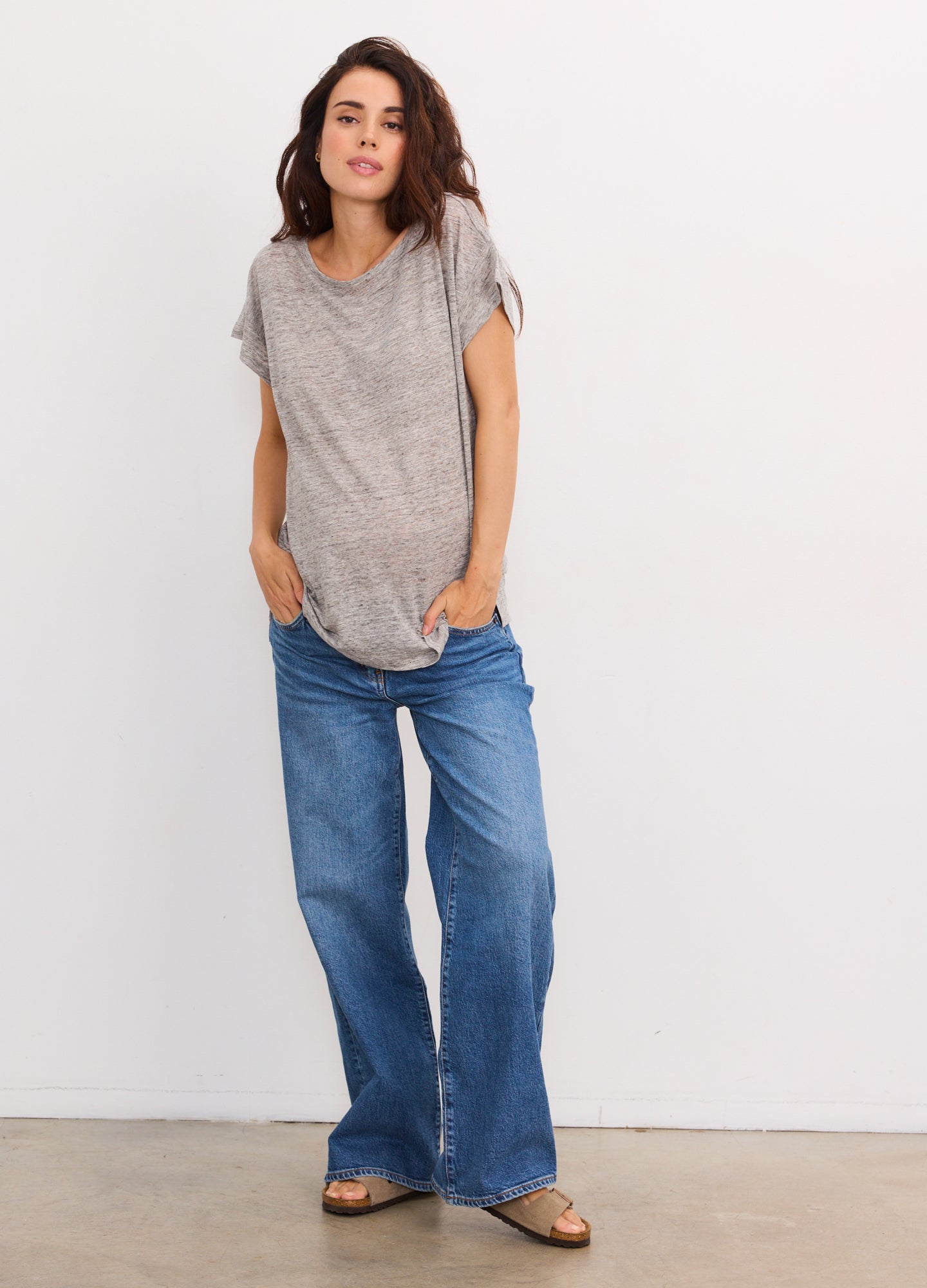Light grey short-sleeve maternity linen tee with relaxed fit, paired with blue denim jeans.