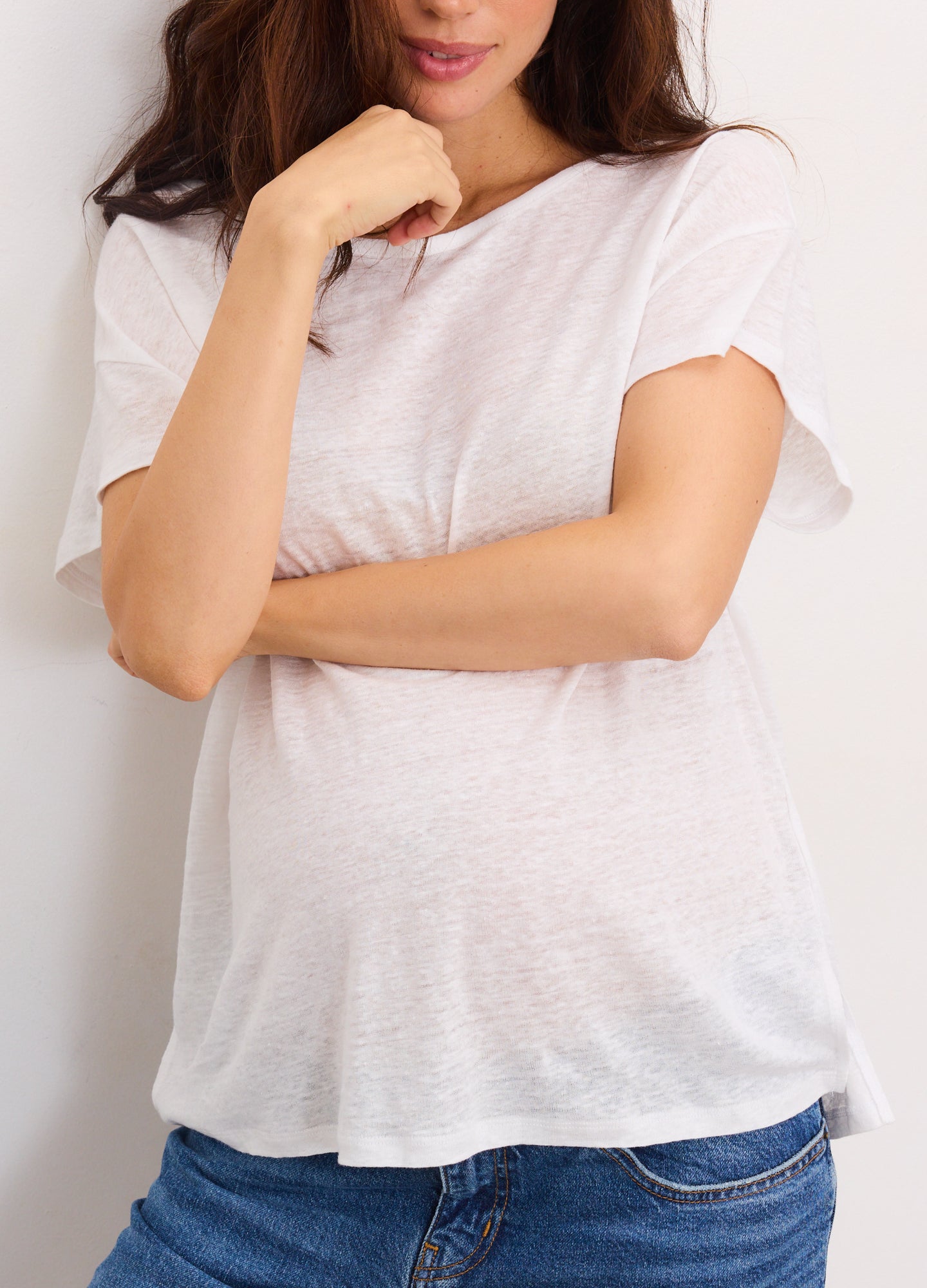 Soft white linen maternity tee with short sleeves and relaxed fit over pregnant belly.