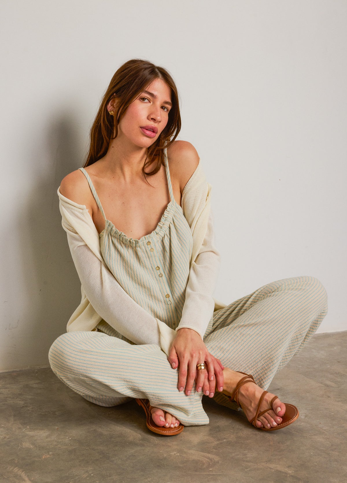 Light beige maternity pants with a relaxed fit, paired with a matching loose cardigan and camisole.