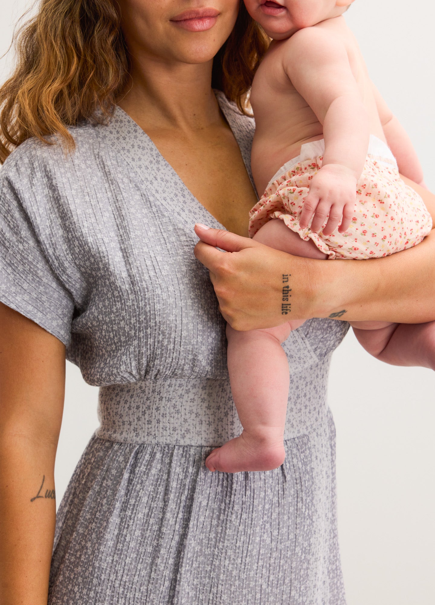 Light gray maternity dress with white jacquard dots, short sleeves, and V-neckline.