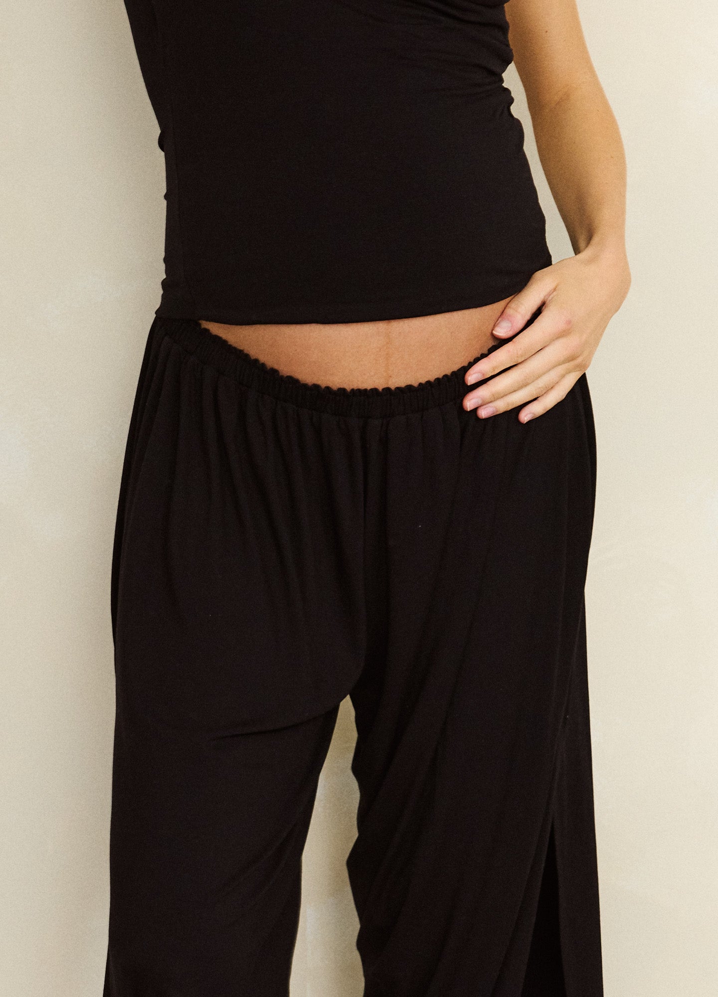 Black maternity pants with a soft elastic waistband and relaxed, flowing fabric tailored for pregnancy comfort.