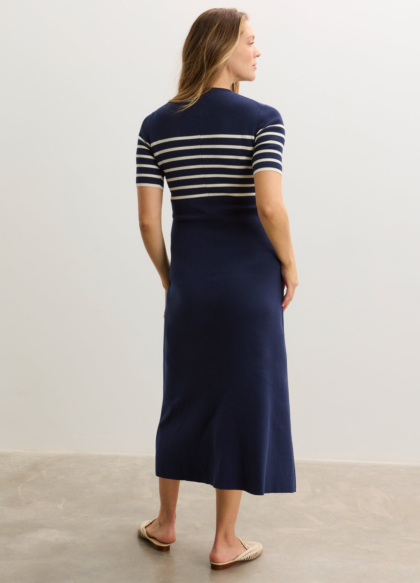 Navy blue ribbed cotton maternity dress with white horizontal stripes on top, short sleeves, and a mid-calf length.