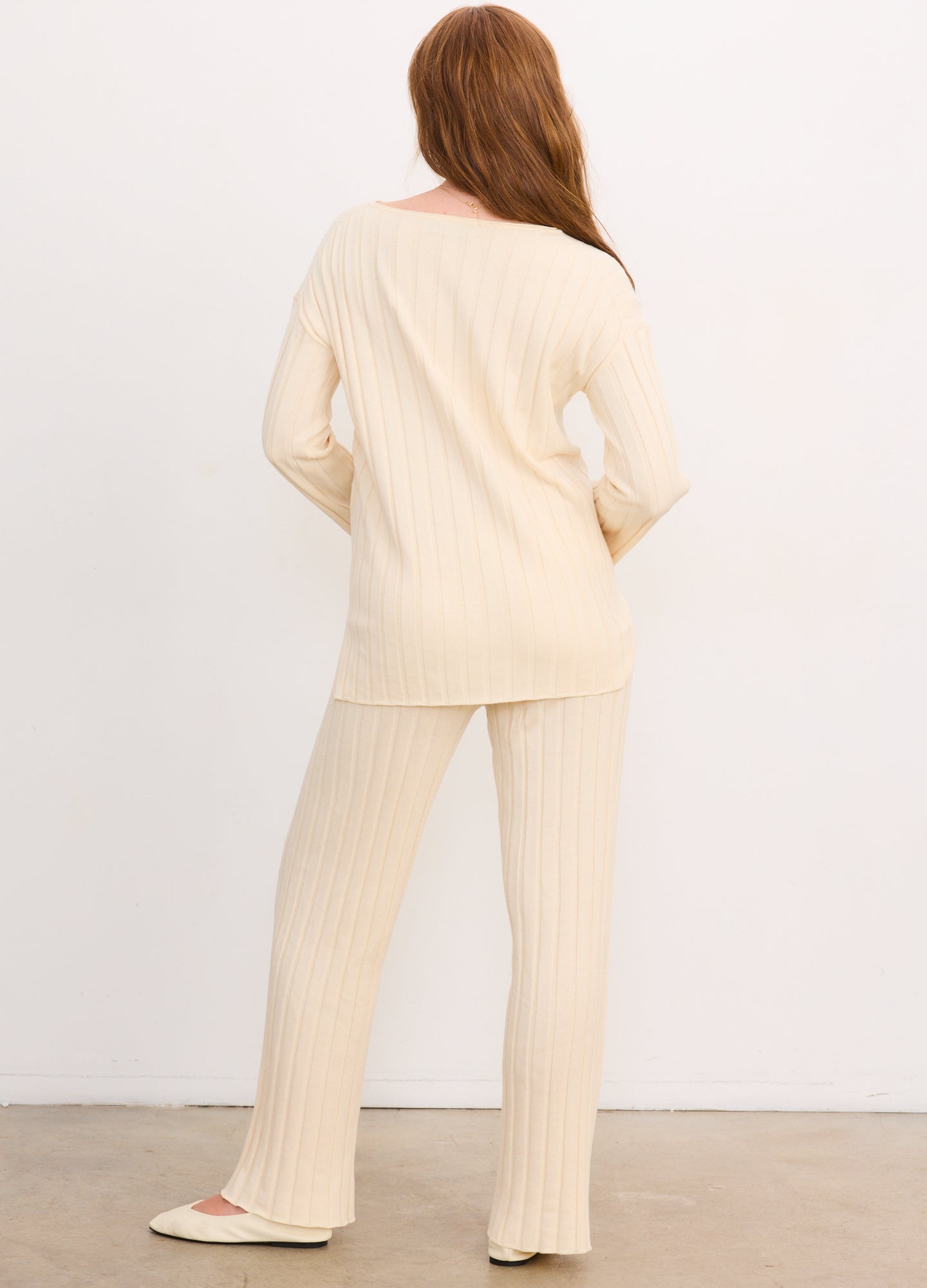 Cream-colored ribbed cotton maternity pullover with long sleeves and matching ribbed pants.