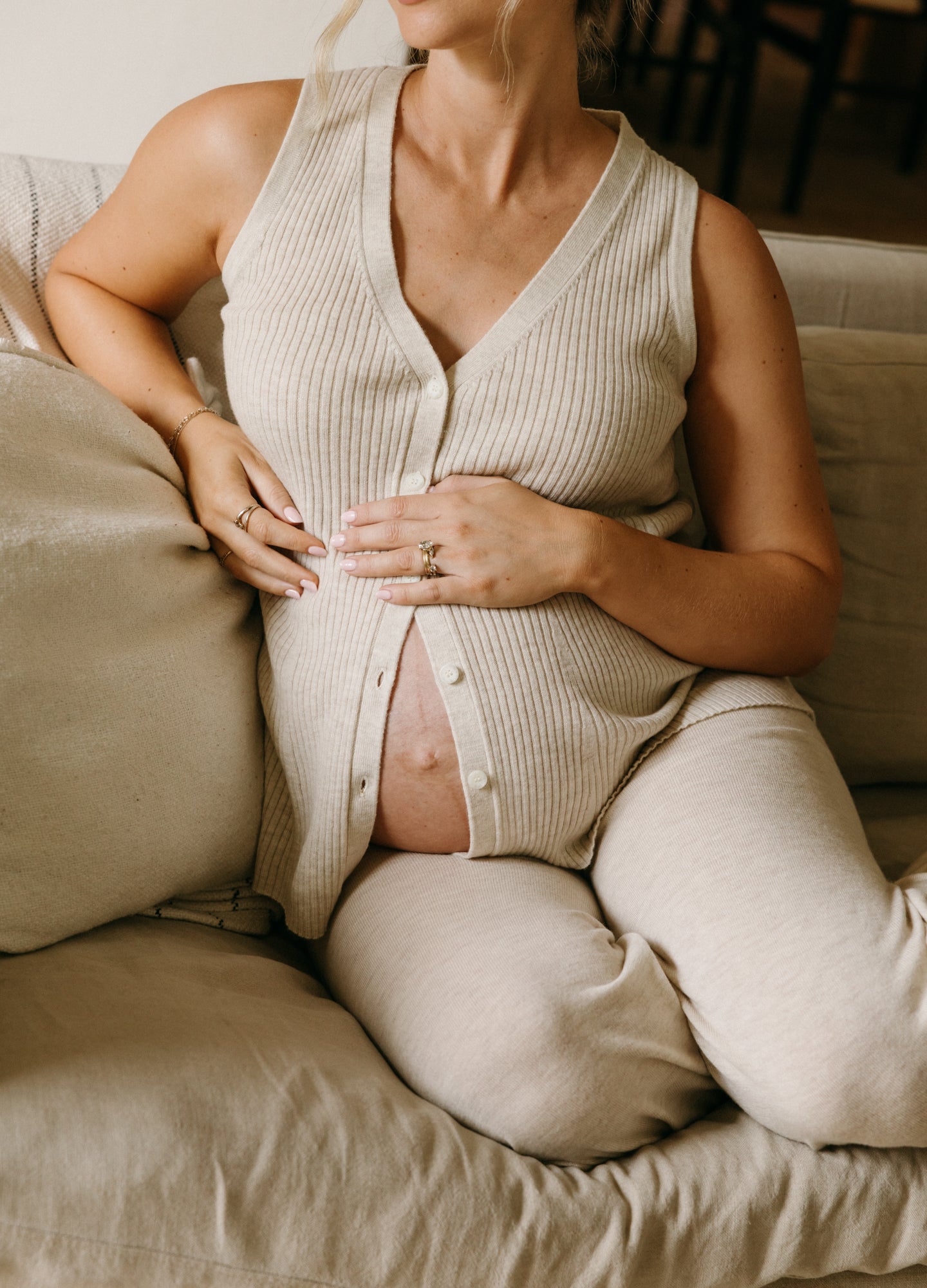 Beige ribbed knit nursing tank with front snap closures, sleeveless maternity top designed for 4th trimester comfort.