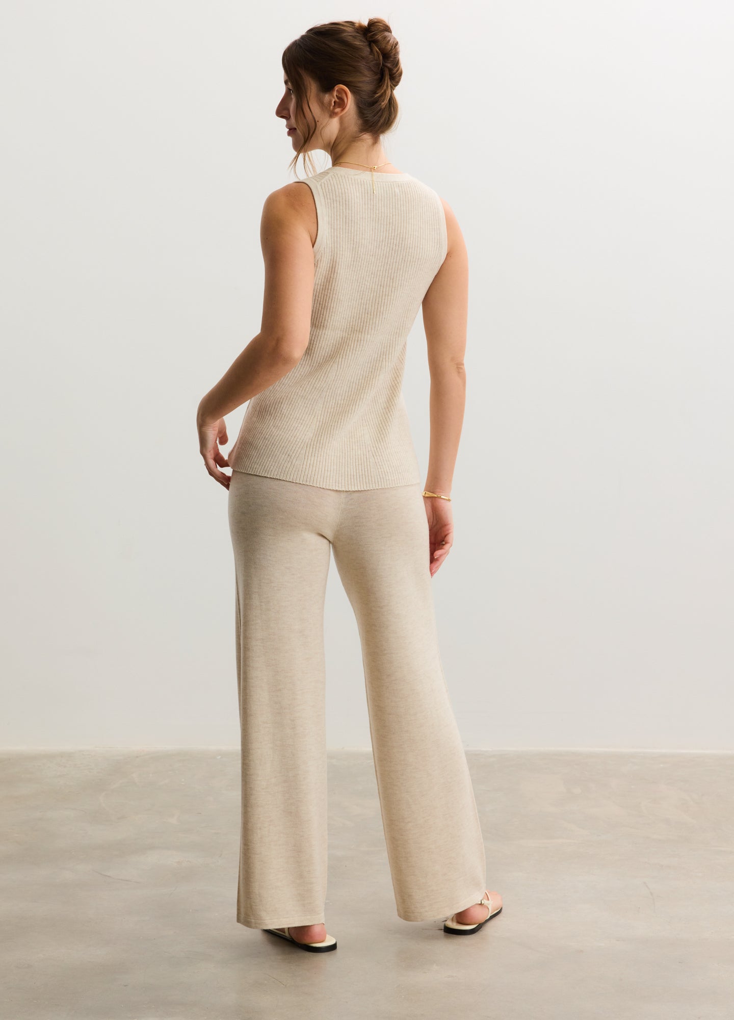 Beige knit sleeveless nursing tank with matching wide-leg maternity pants.