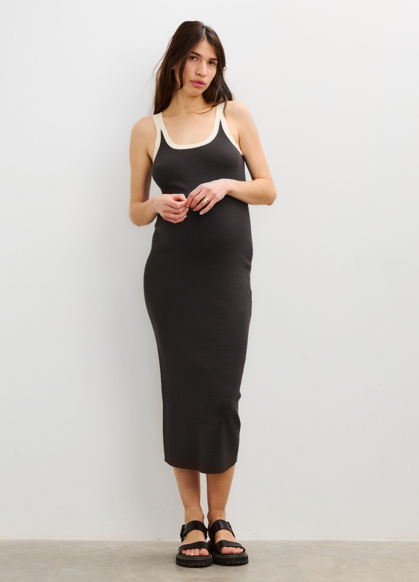 Black sleeveless maternity dress with scoop neck and fitted silhouette, midi length.