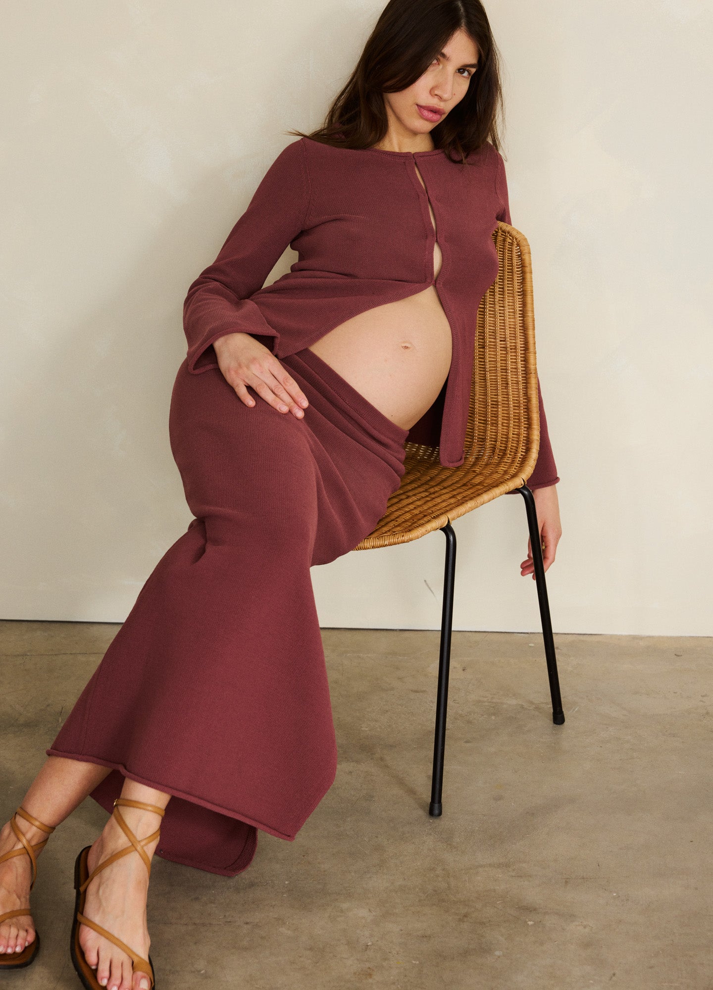 Mauve maternity maxi skirt with stretchy waistband, worn by pregnant woman seated on chair.