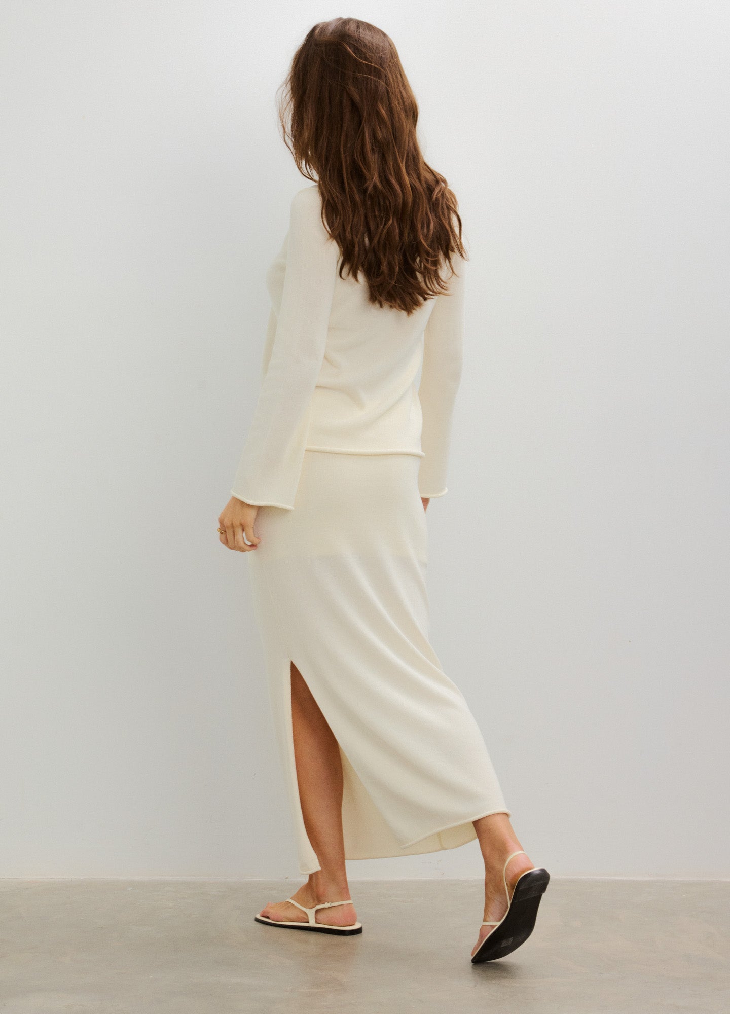 Cream-colored maternity skirt with a back slit, soft knit fabric, and a comfortable fit for pregnant women.