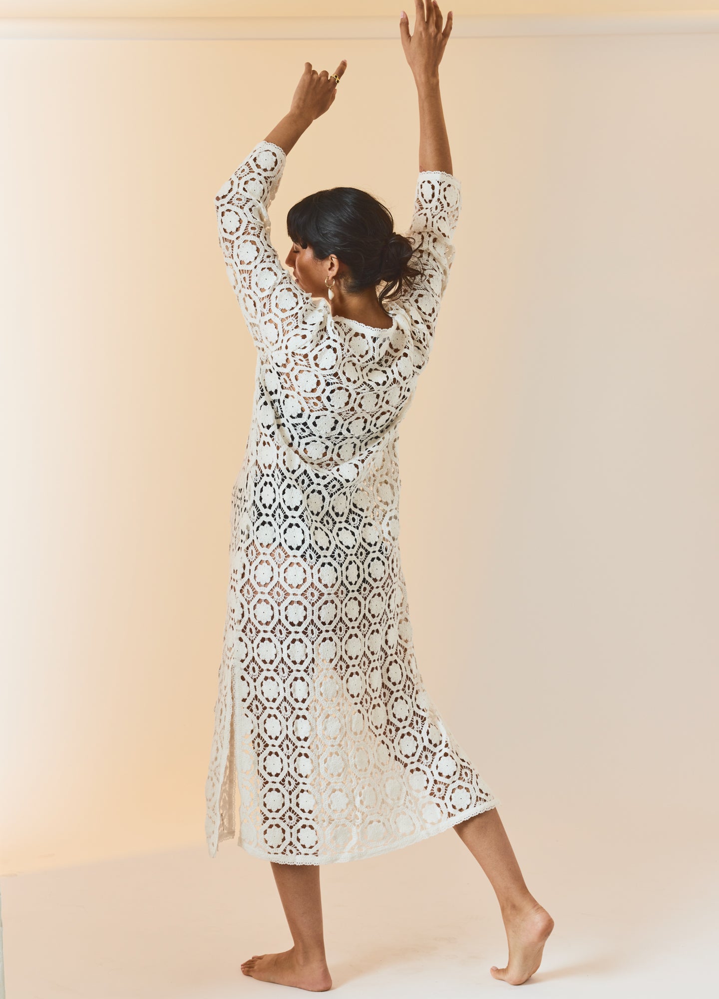 White crochet midi cover-up dress with three-quarter sleeves and side slits, modeled on a pregnant woman.