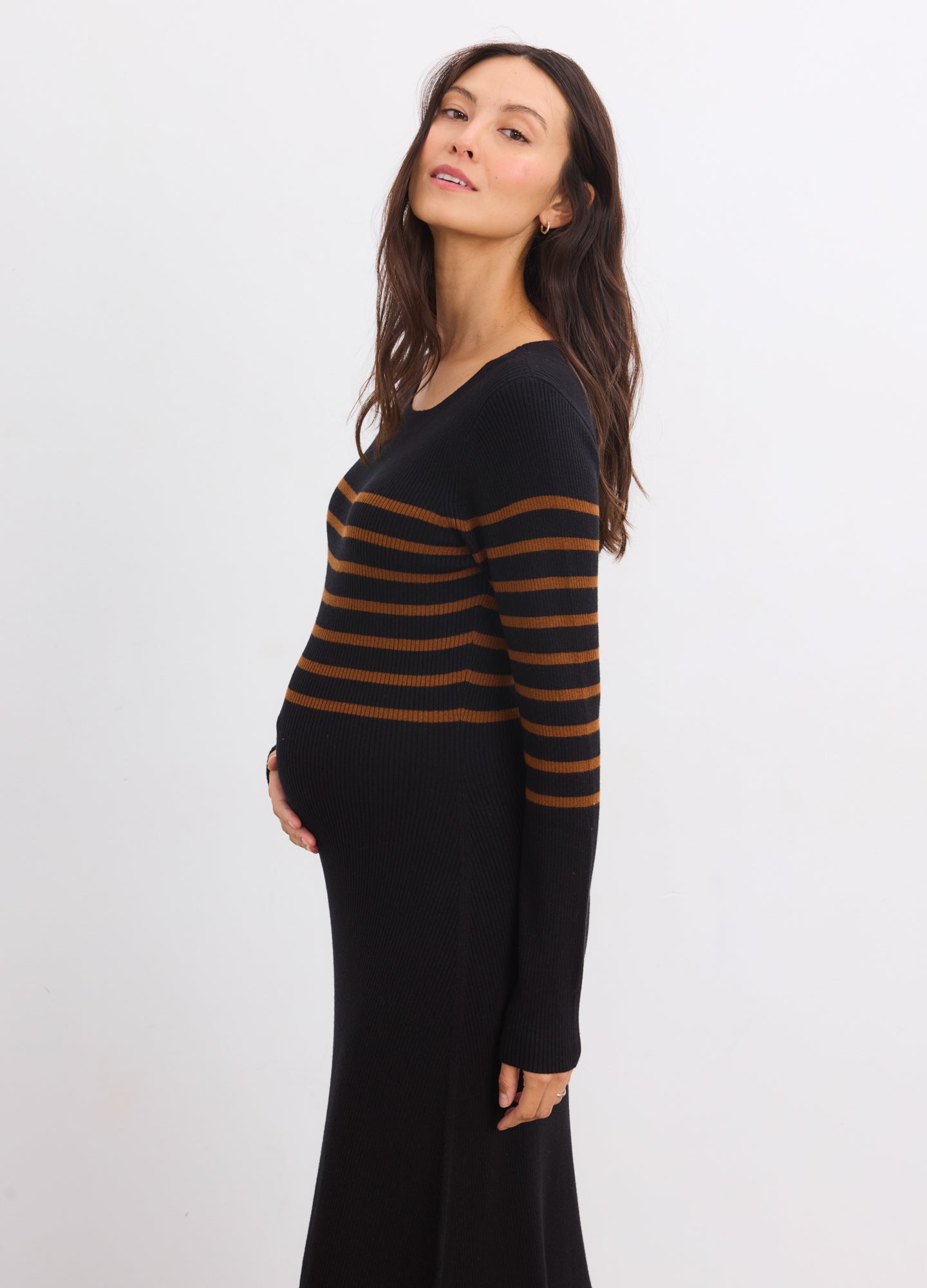 Black knit sweater dress with brown horizontal stripes, long sleeves, fitted maternity silhouette.