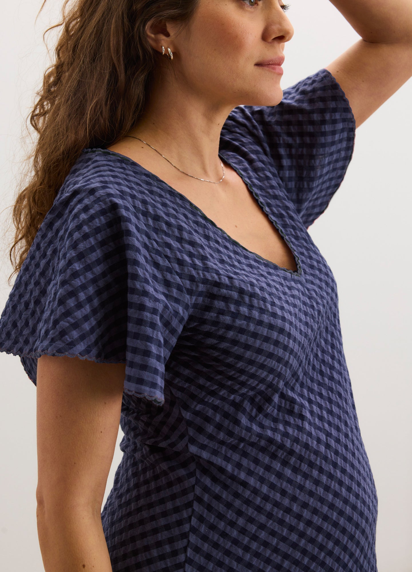 Navy blue textured maternity dress with short flutter sleeves and a V-neckline.