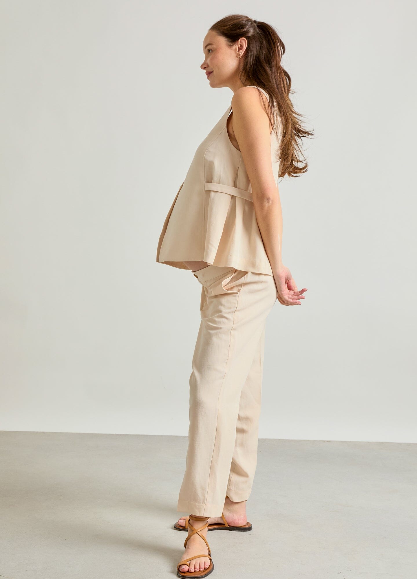 The Nadia Vest - Black sleeveless maternity vest with buttons and side pockets, designed for pregnancy, nursing, and postpartum.