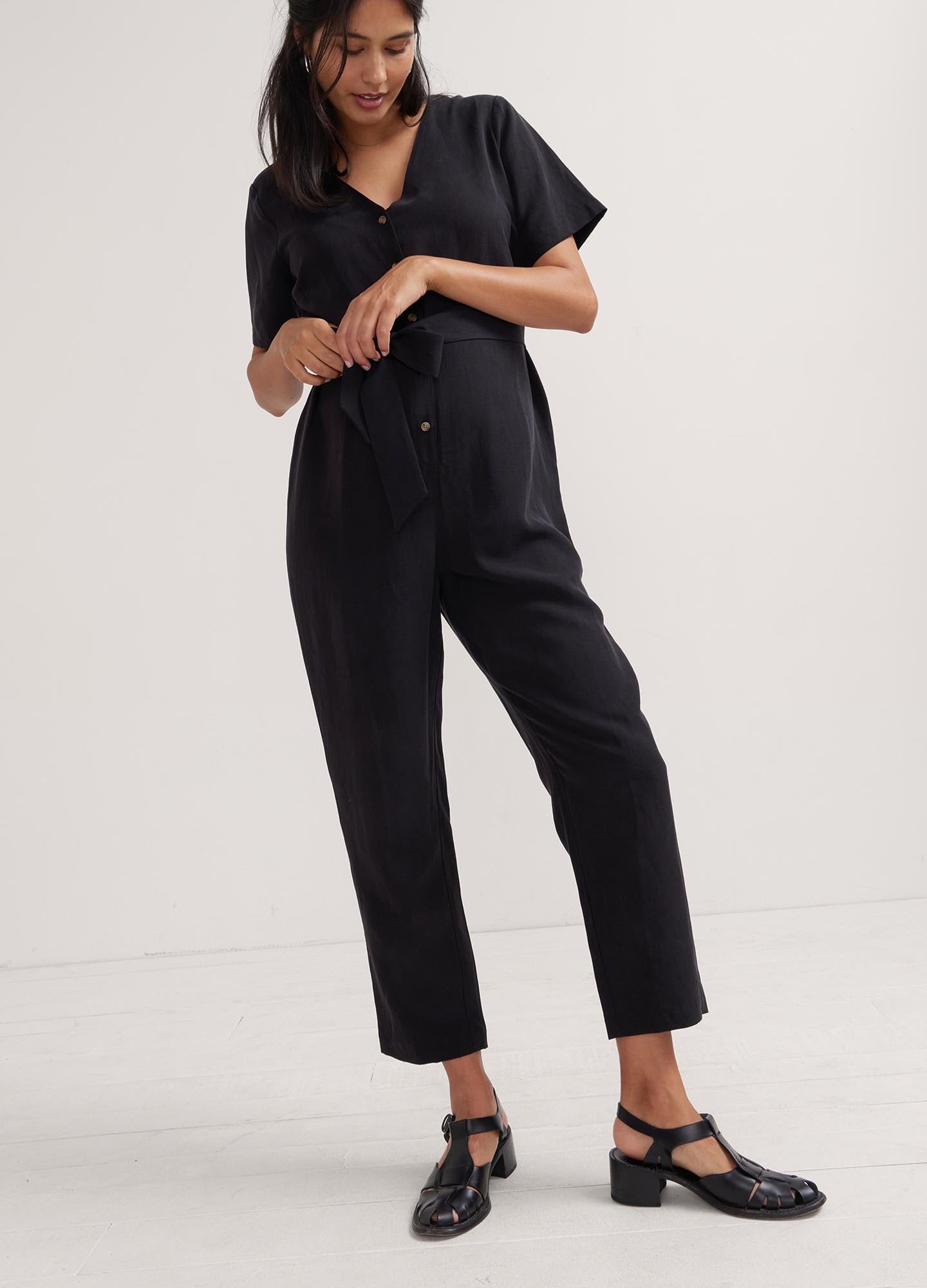 The Noelle Jumpsuit - Black short-sleeve maternity jumpsuit with button front, tailored fit for nursing and postpartum comfort.