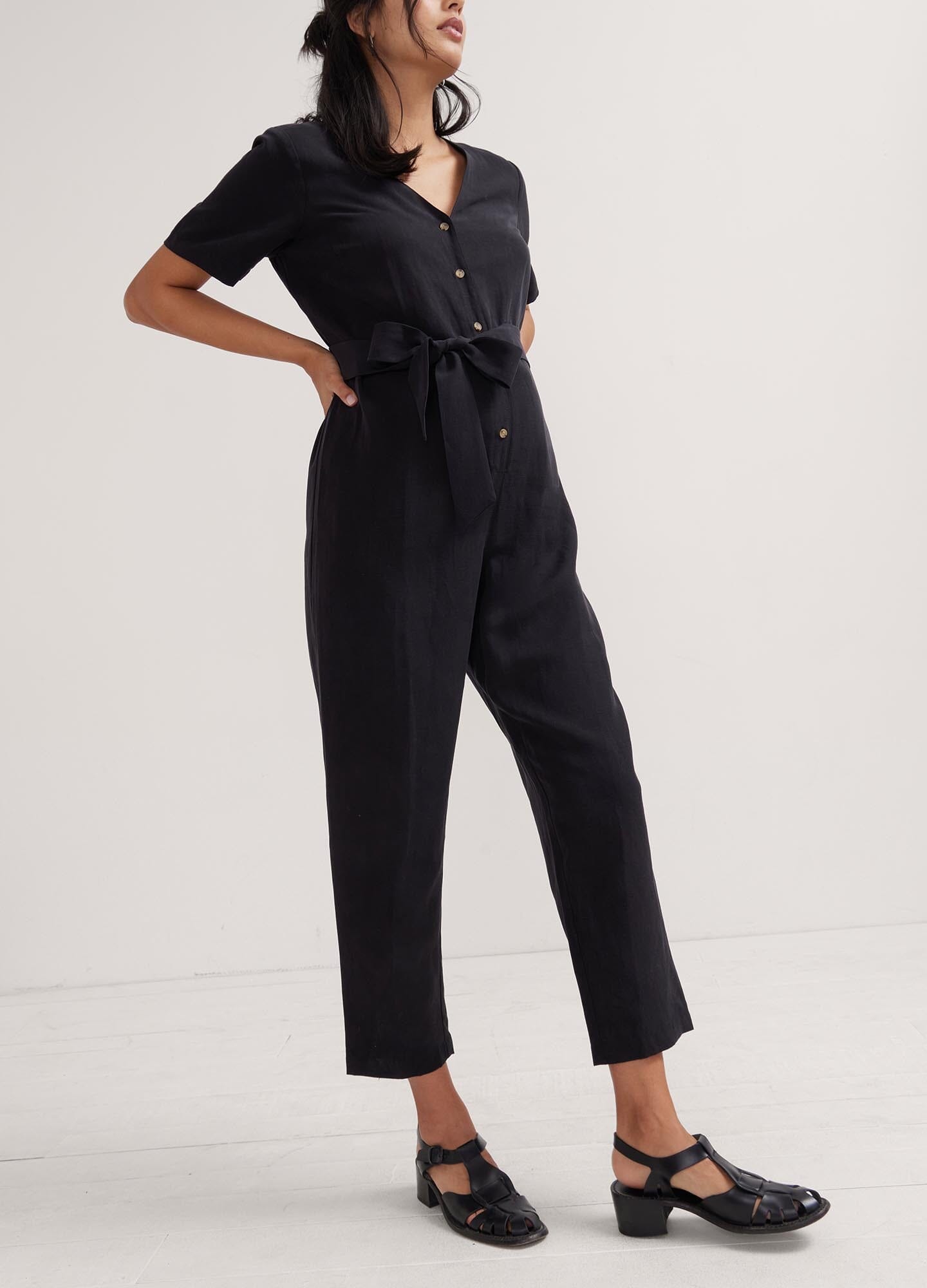 The Noelle Jumpsuit - Black short-sleeve maternity jumpsuit with button front, tailored fit for nursing and postpartum comfort.